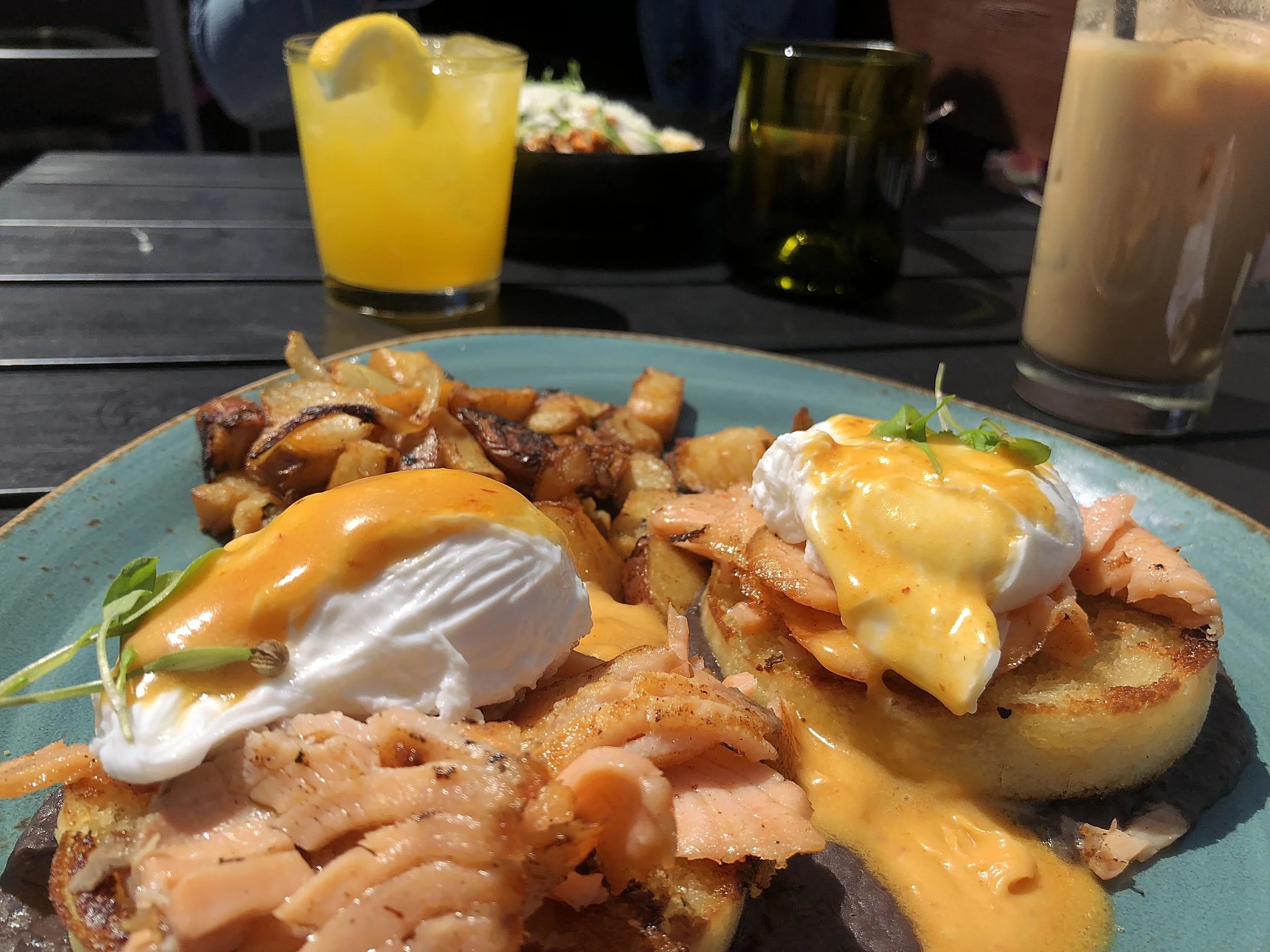 Smoked salmon Benedict (front), a classic mimosa (back left), and “hair of the dog” (back right).