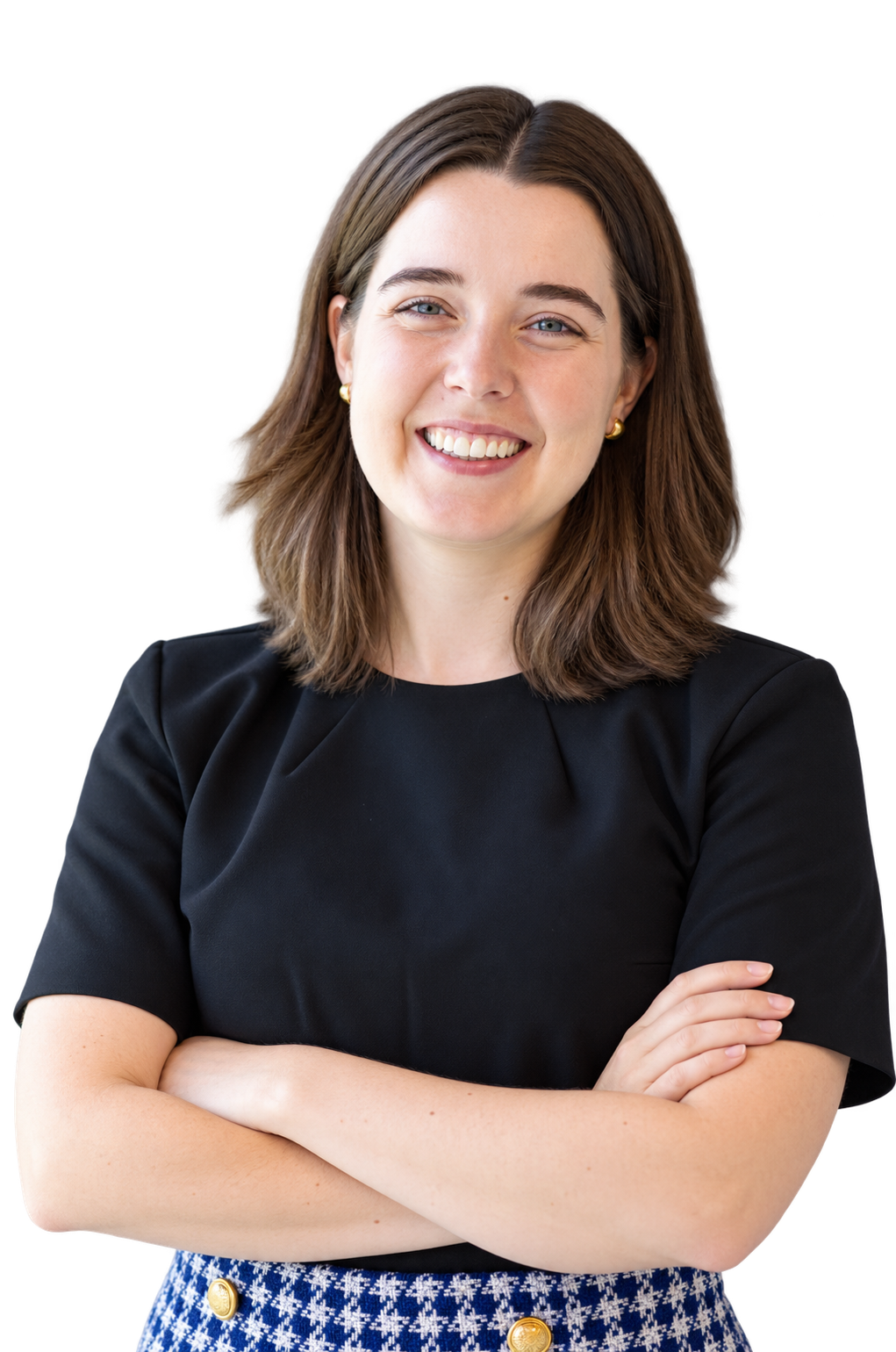 Bailey with brown medium length hair, gold earrings, black short sleeve shirt, blue checkered high-waisted pants, crossing arms and smiling.
