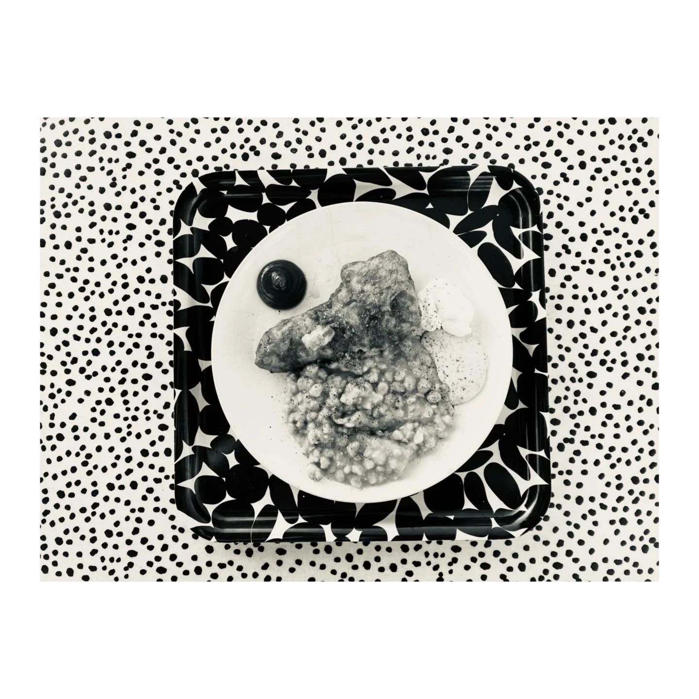 This evening&rsquo;s graphic dinner: a construction of battered haddock, mushy peas, tartare sauce, mayonnaise, ketchup, salt, vinegar and pepper on a circular ceramic plate on a square tray on a patterned tablecloth in the garden. Approximate time o