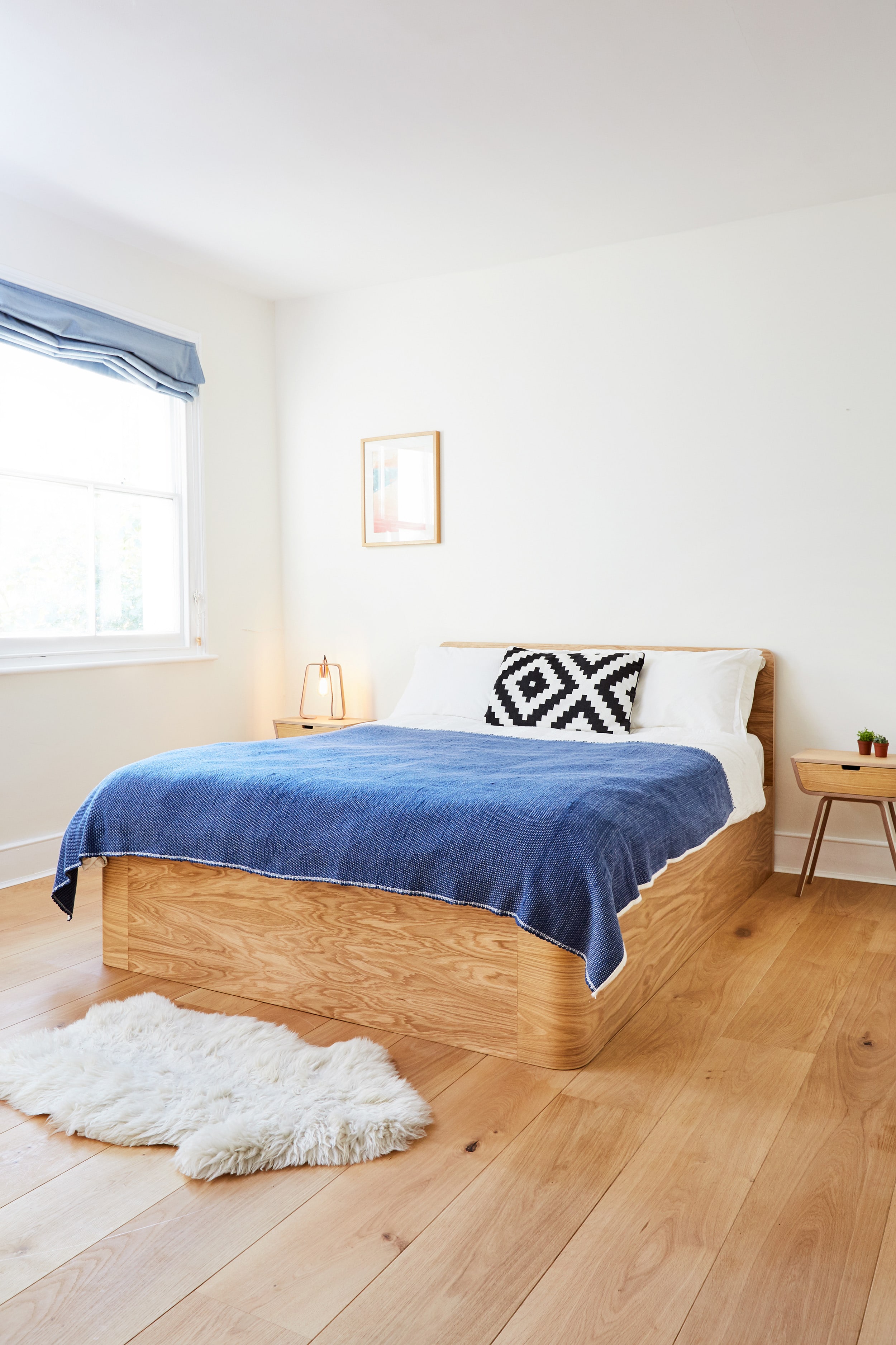 Curved plywood bed frame by Lozi, with storage drawer and headboard.