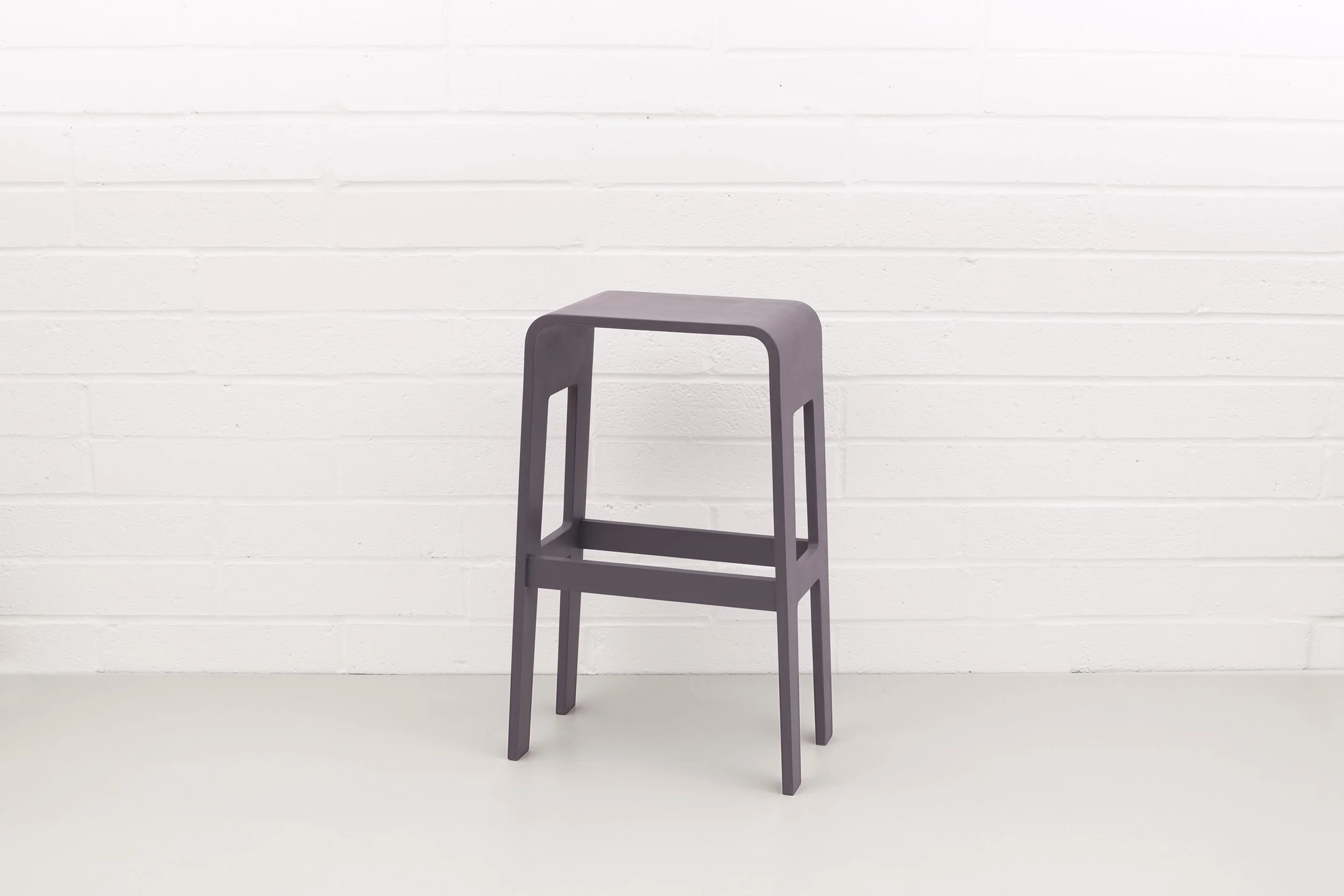 Front view of Lozi's curved plywood barstool, painted Driftwood Grey