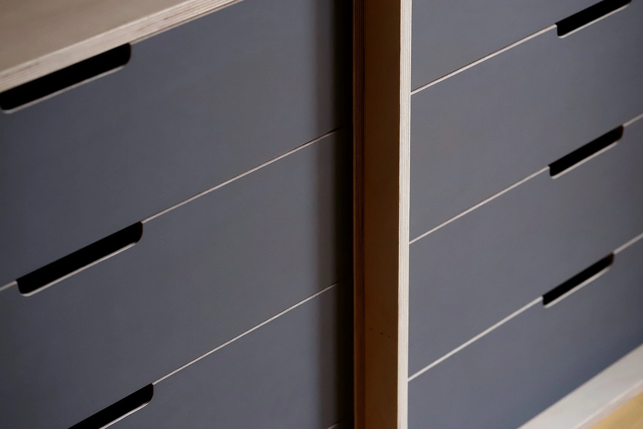 The dark grey drawers help elongate the space.