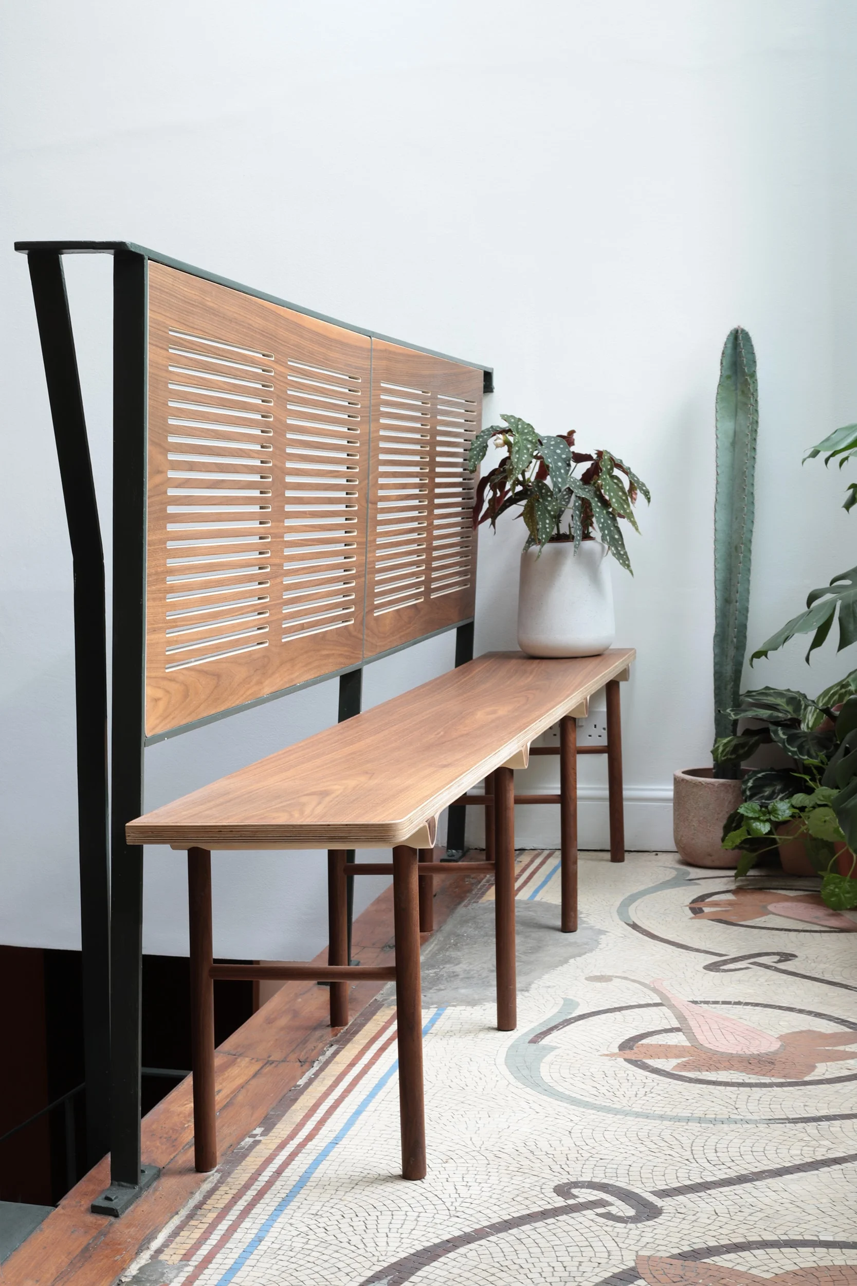 Lozi’s bespoke wave bench in walnut uses handrail as a backrest, optimising the waiting area space.