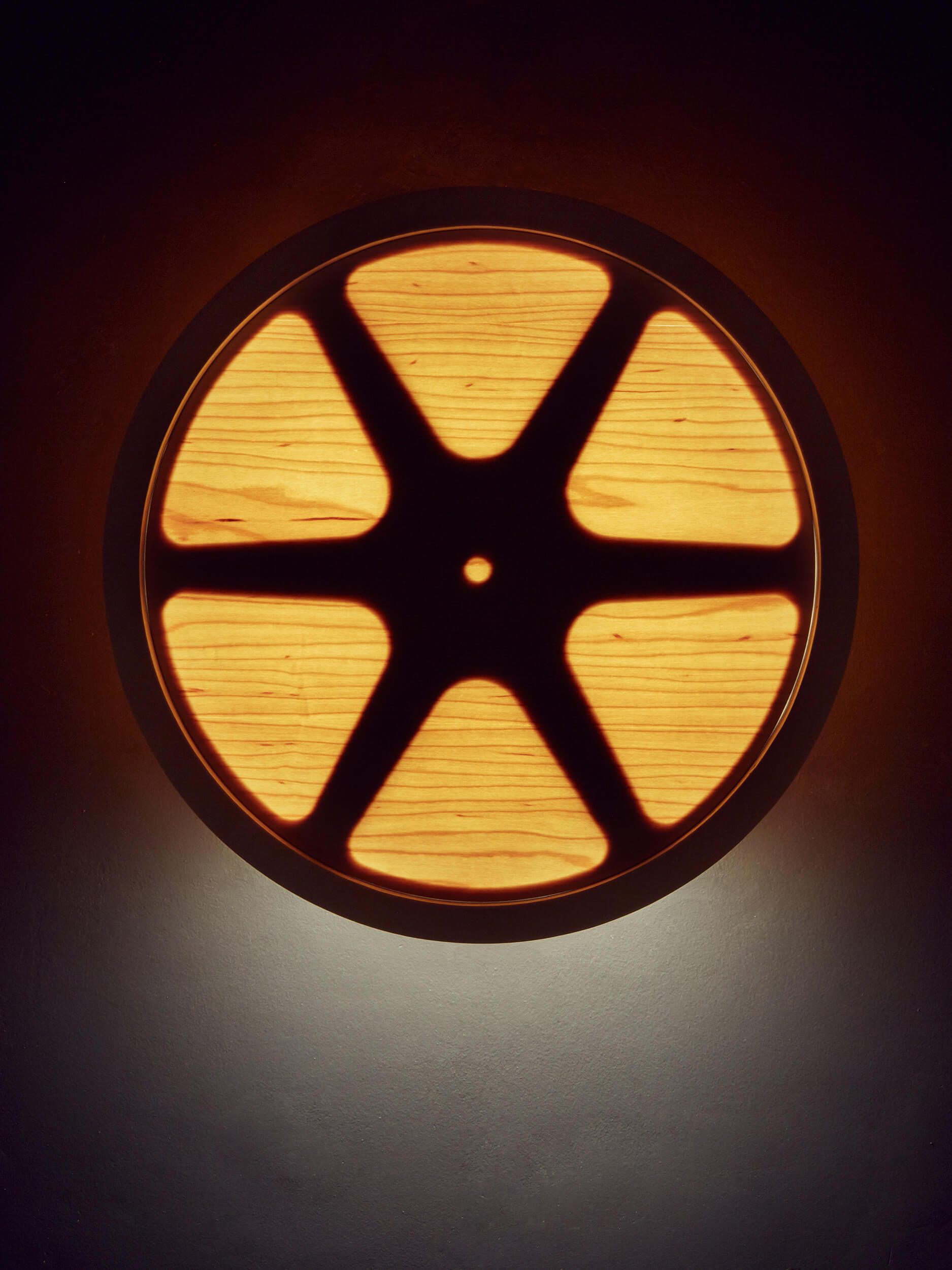 A close up of the wall mounted film reel Sunset lamp