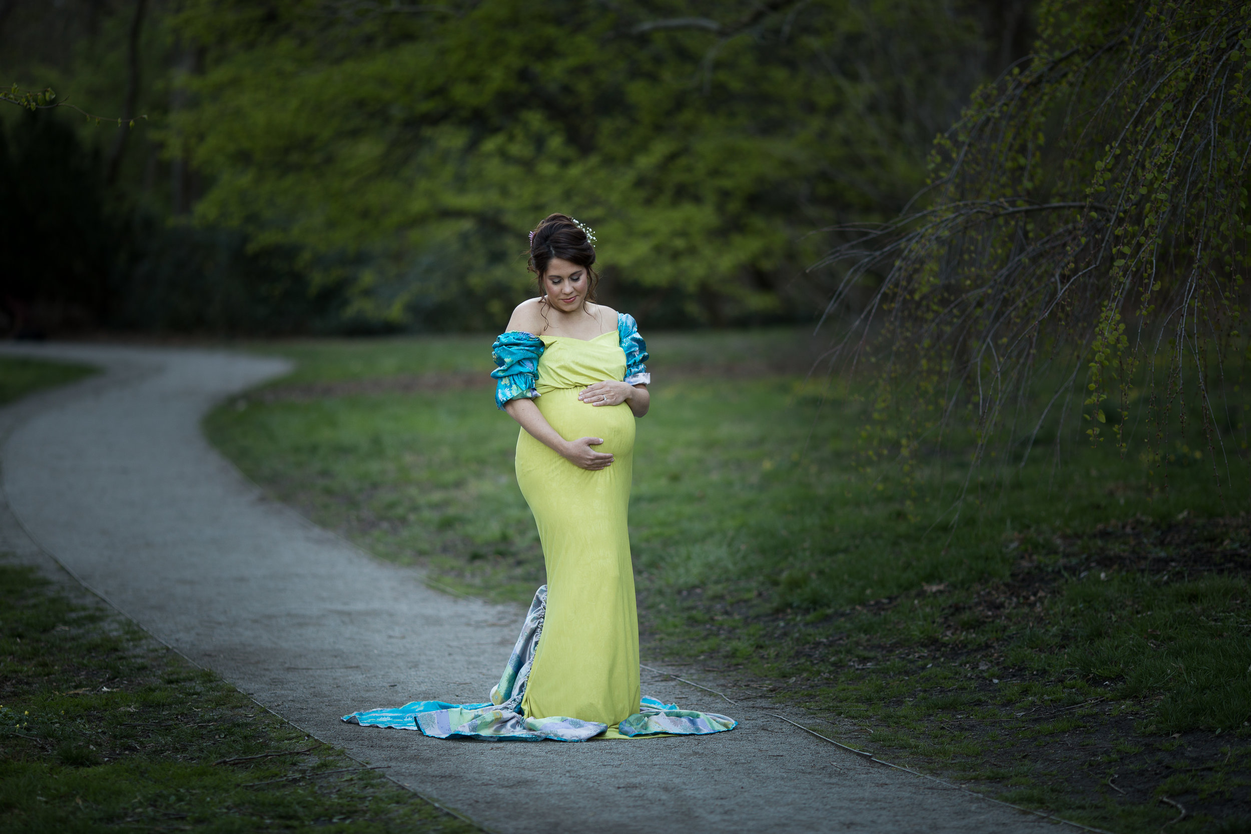 designer maternity dress on expecting mom with path in background