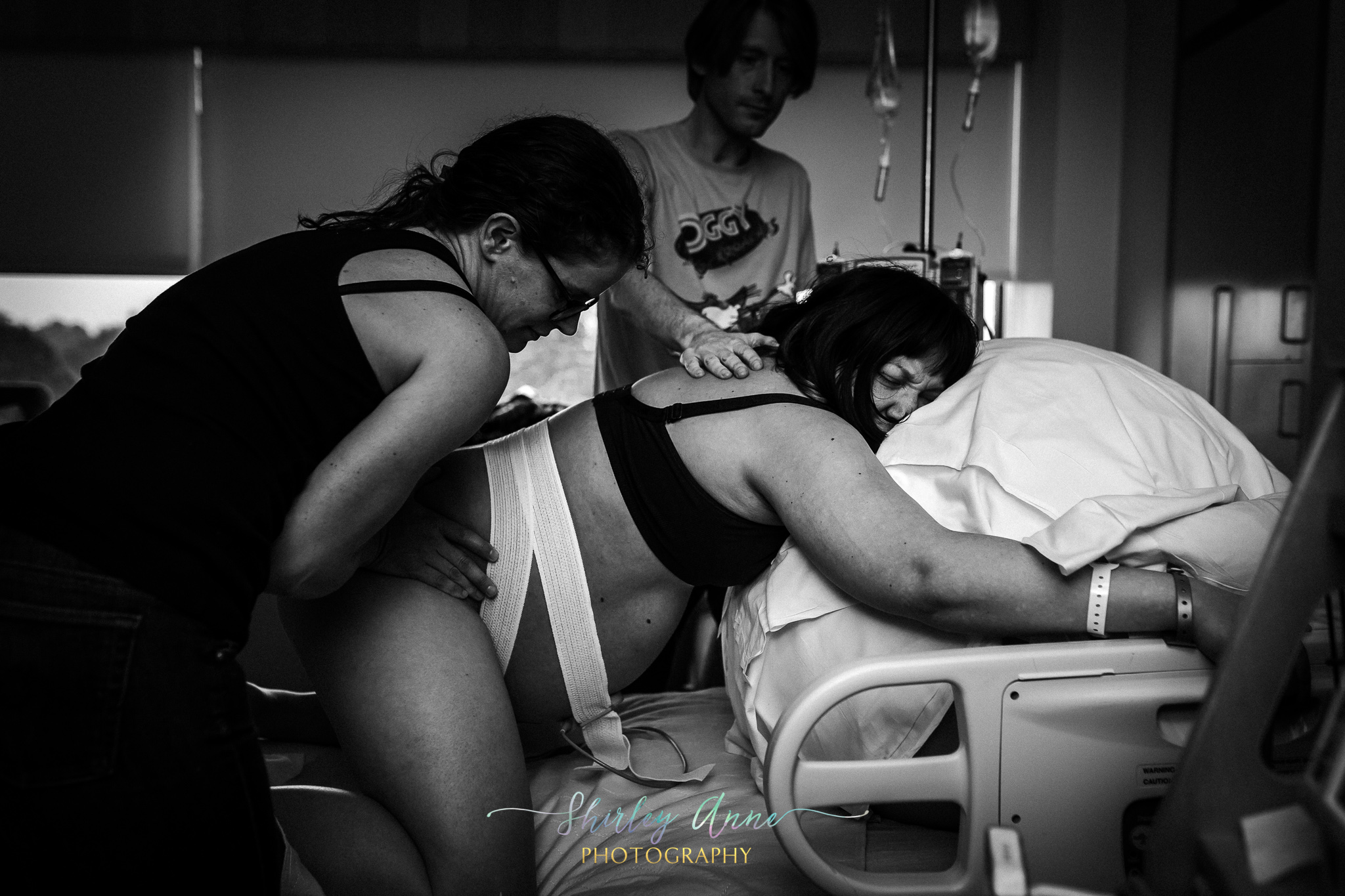 mom supported by doula and husband during labor in hospital