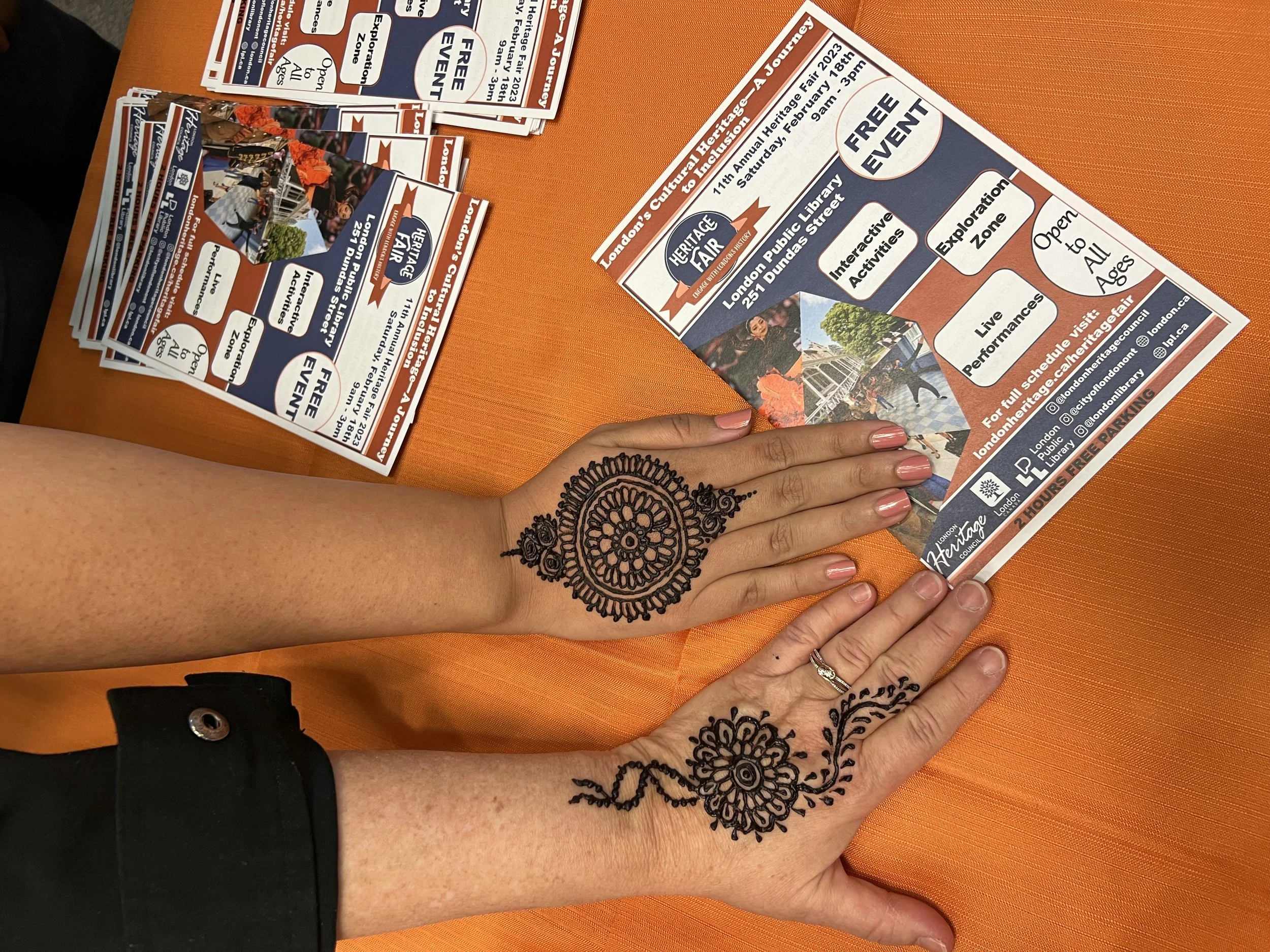 Two women's hands decorated with henna