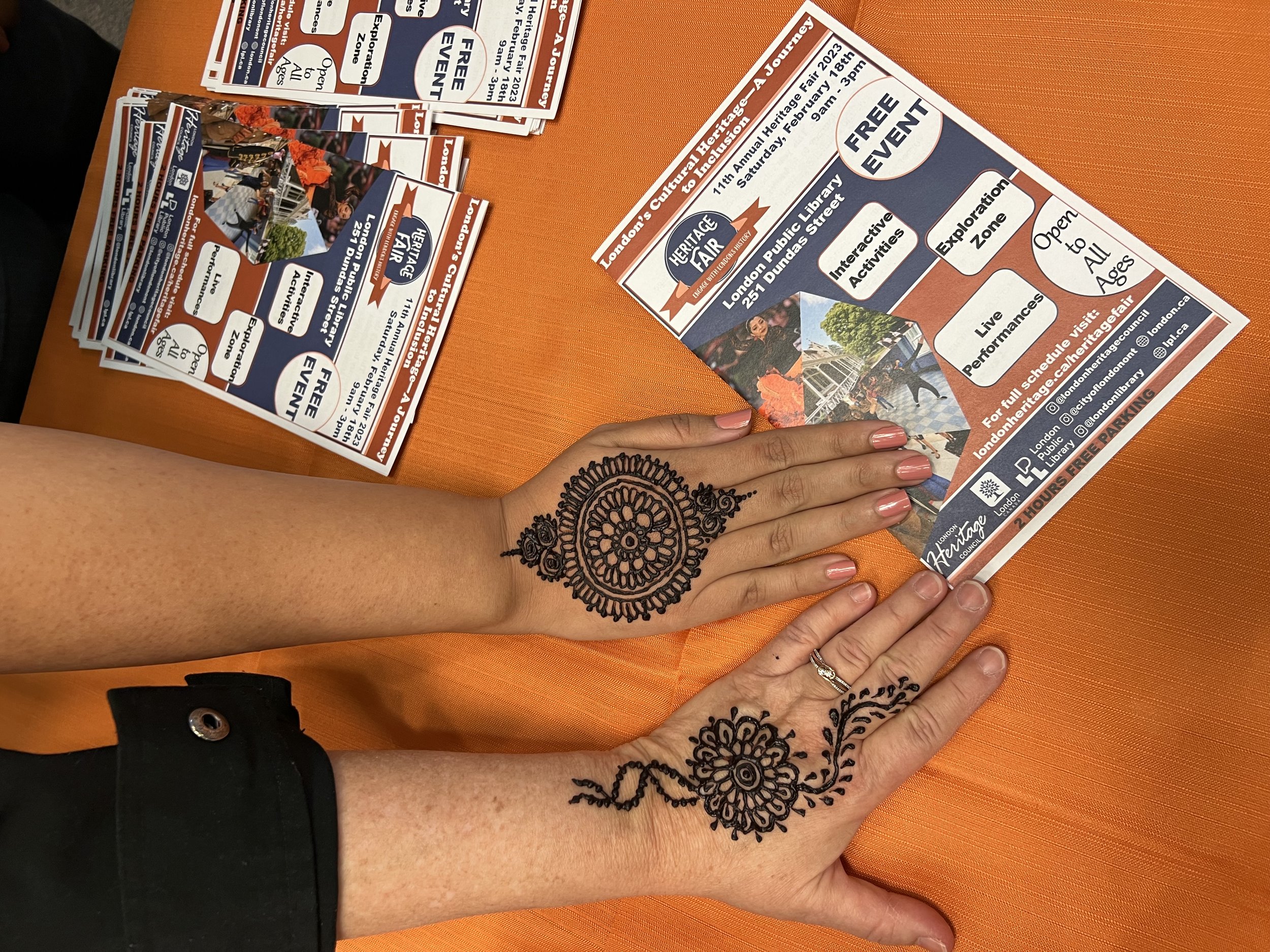 Two women's hands decorated with henna
