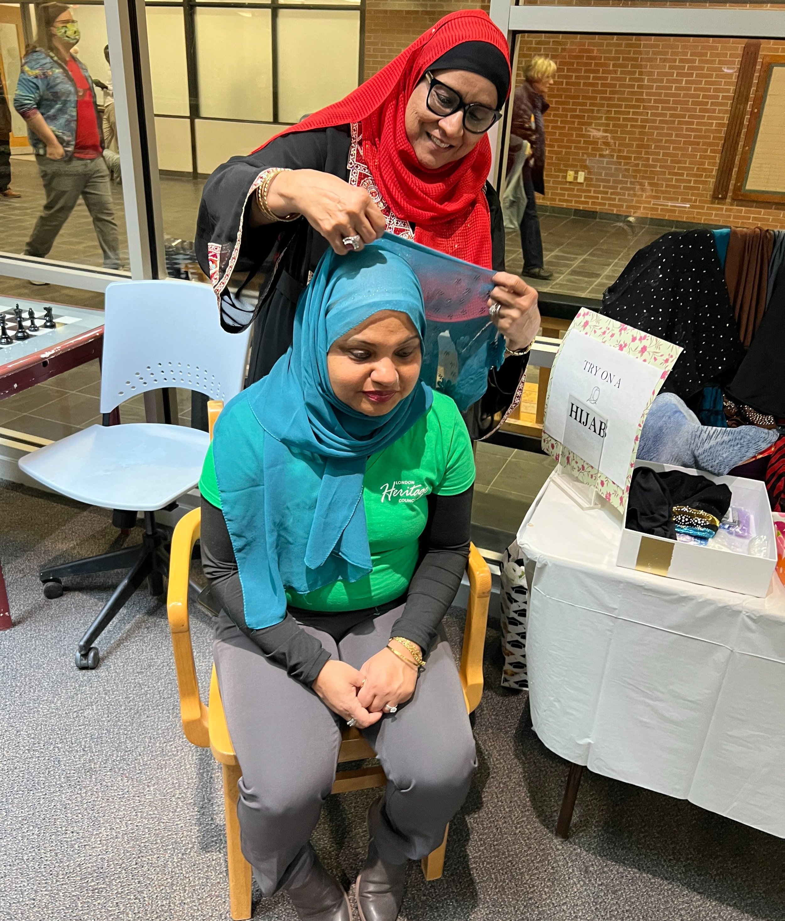 Hijab wrapping demonstration between two women