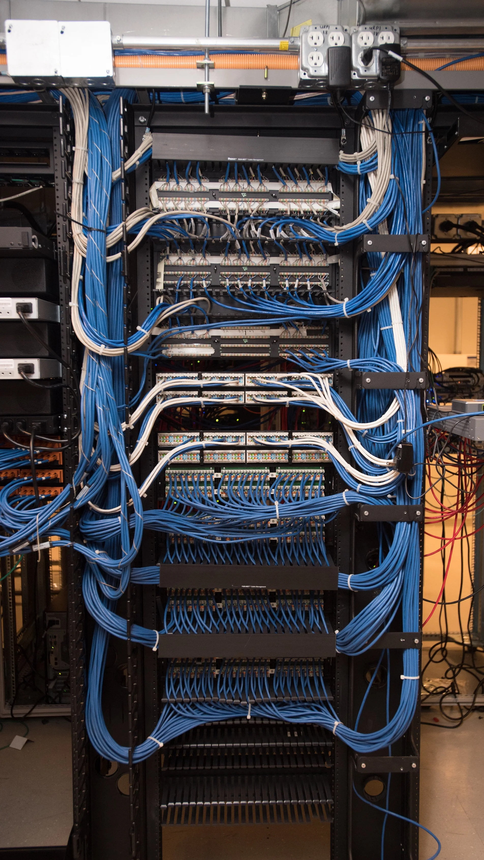 Photo of a computer server room with lots of wires