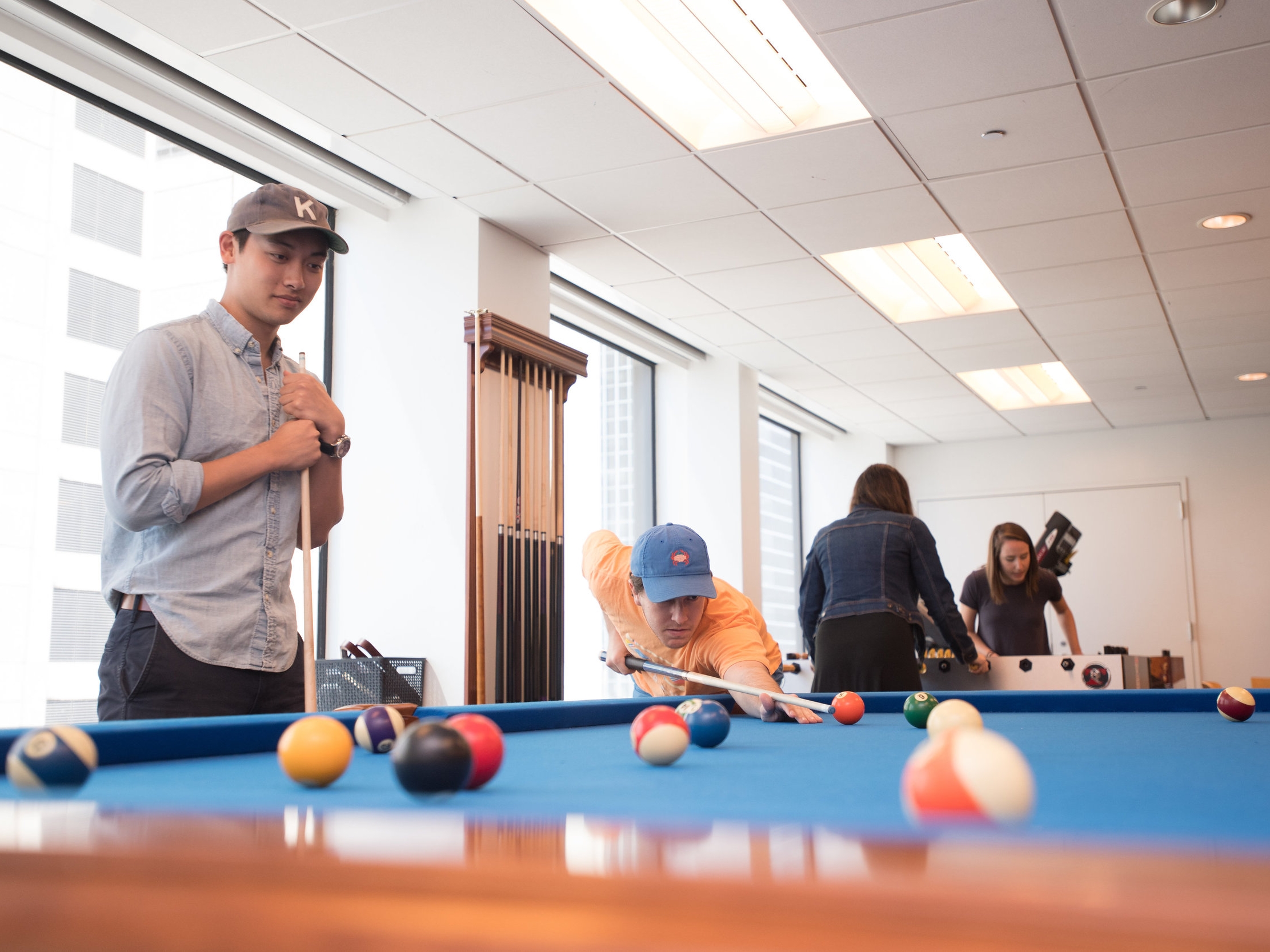 People play pool in the game room.