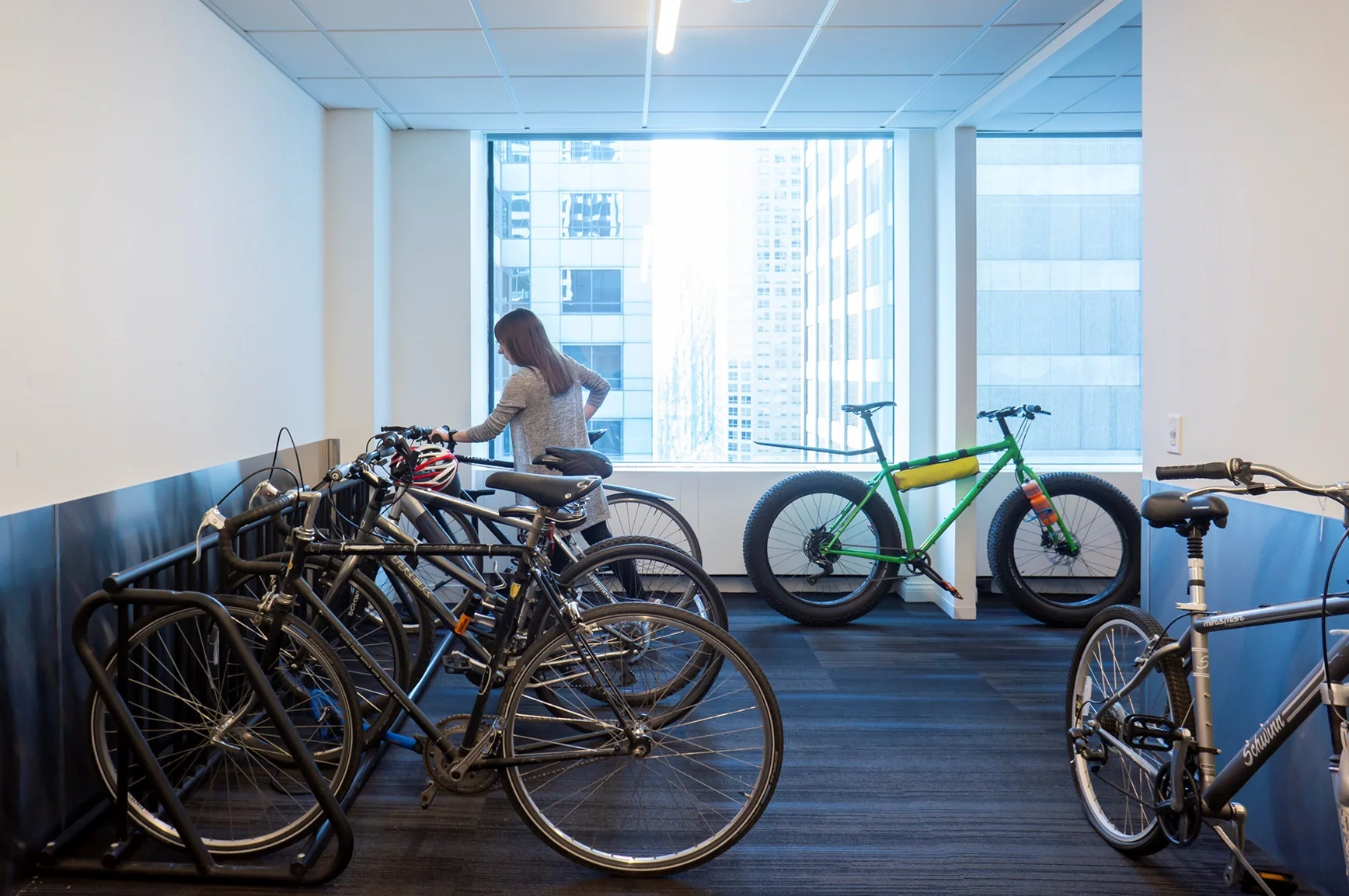 A woman stores her bike in the in-office bike storage room.