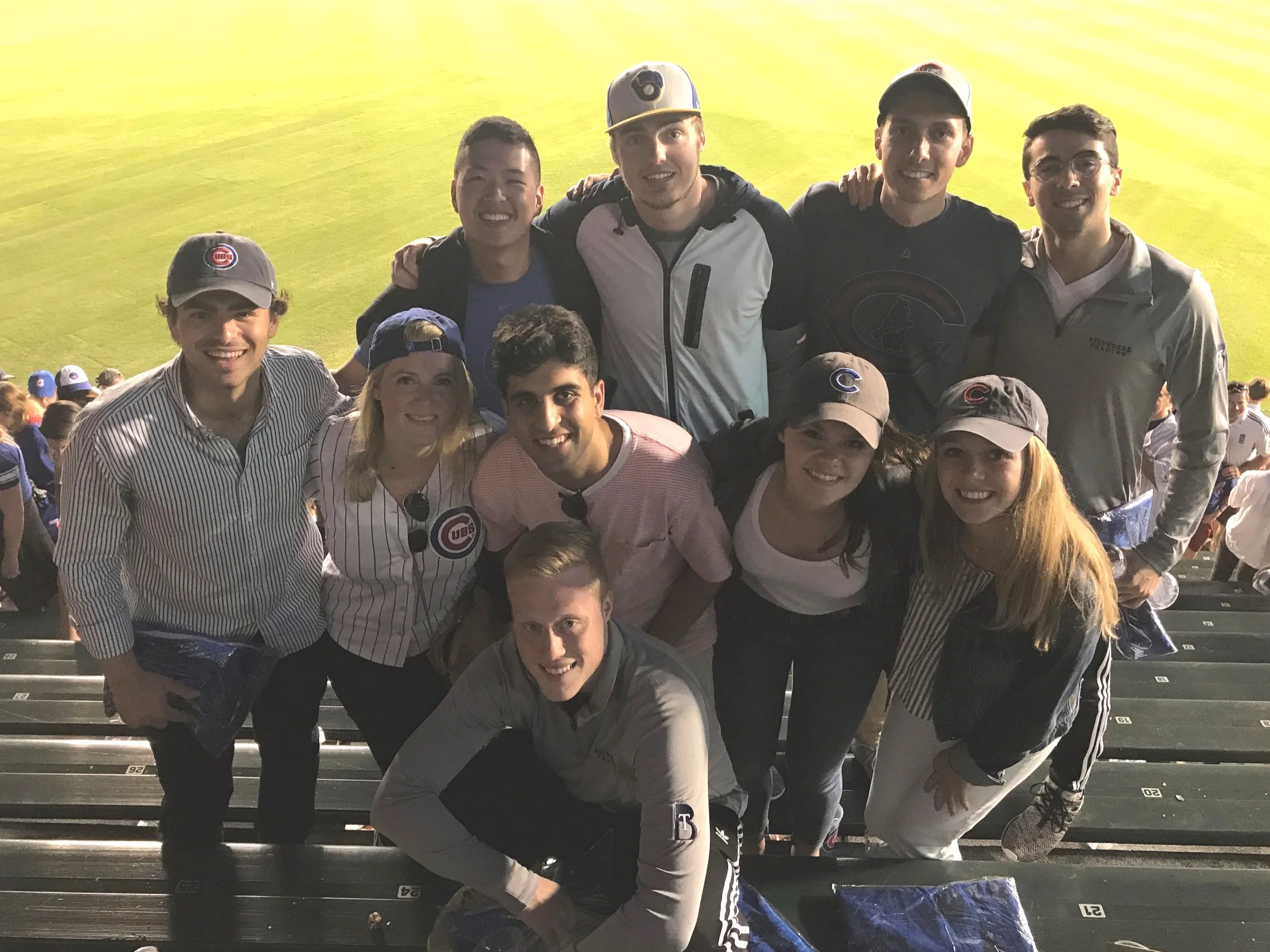 A group of people at a Cubs game pose for a photo.