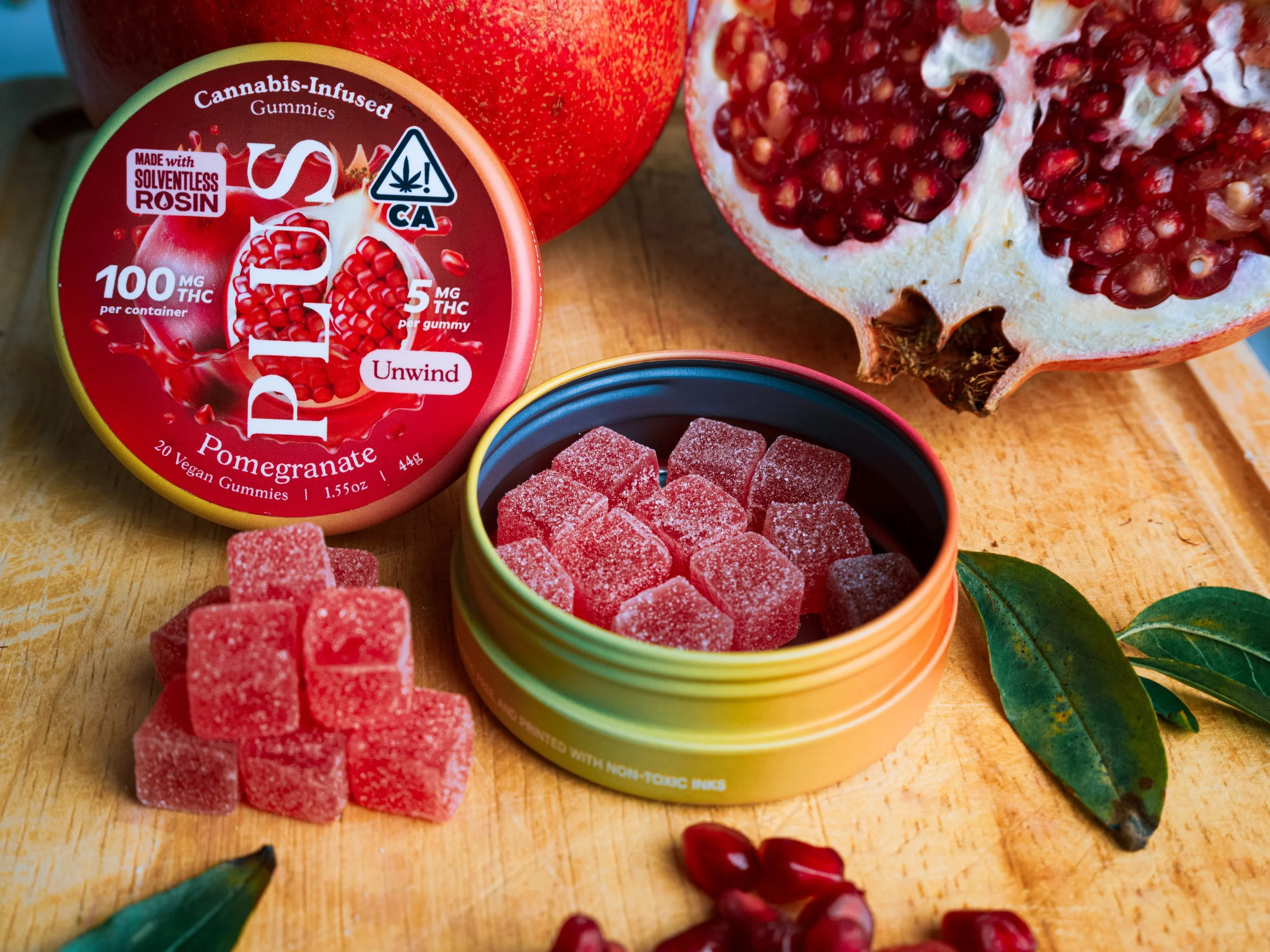 plus pomegranate tin and gummies with pomegranate fruit and leaves