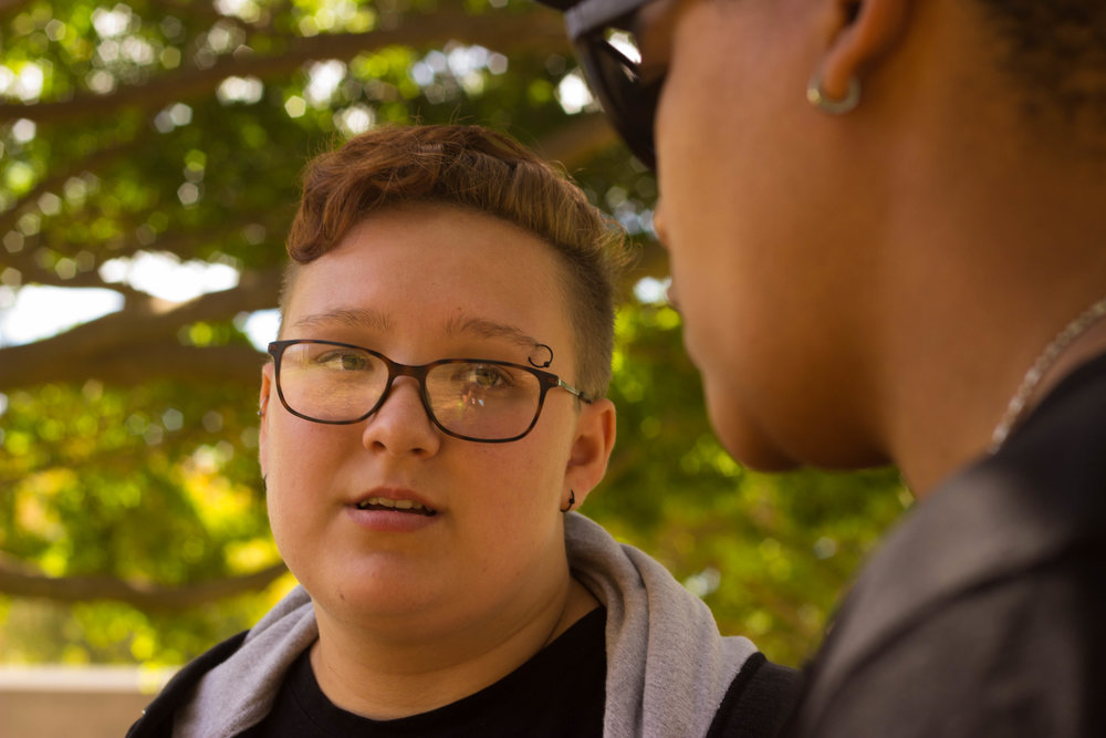 Student with glasses talking to Causha, the teen advocate.
