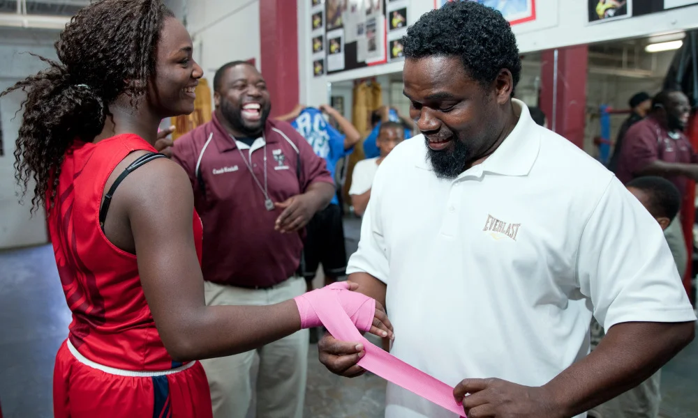 Olympic gold-medallist Claressa Shields laughs with coaches, Ed Kendall , rear center, and Jason Crutchfield as they help wrap her hands before an evening boxing class at the Berston Field House in Flint, Mich. on Tuesday, Oct. 2, 2012. Shields, who won the first women's boxing gold medal at the London Summer Olympics, is currently training for the National Police Athletic League title. (AP Photo/The Flint Journal, Griffin Moores) ORG XMIT: MIFLI704