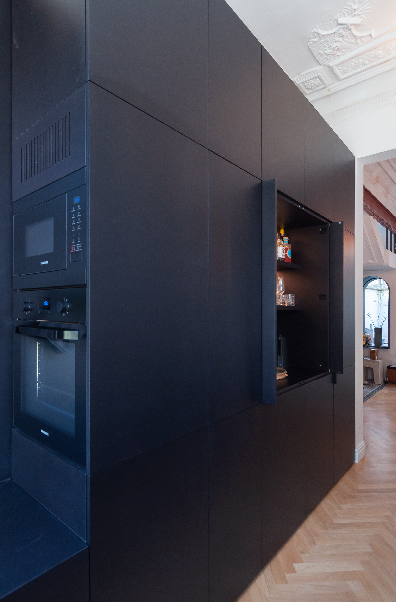  the wall includes a liquor cabinet with folding doors and automated led lights 