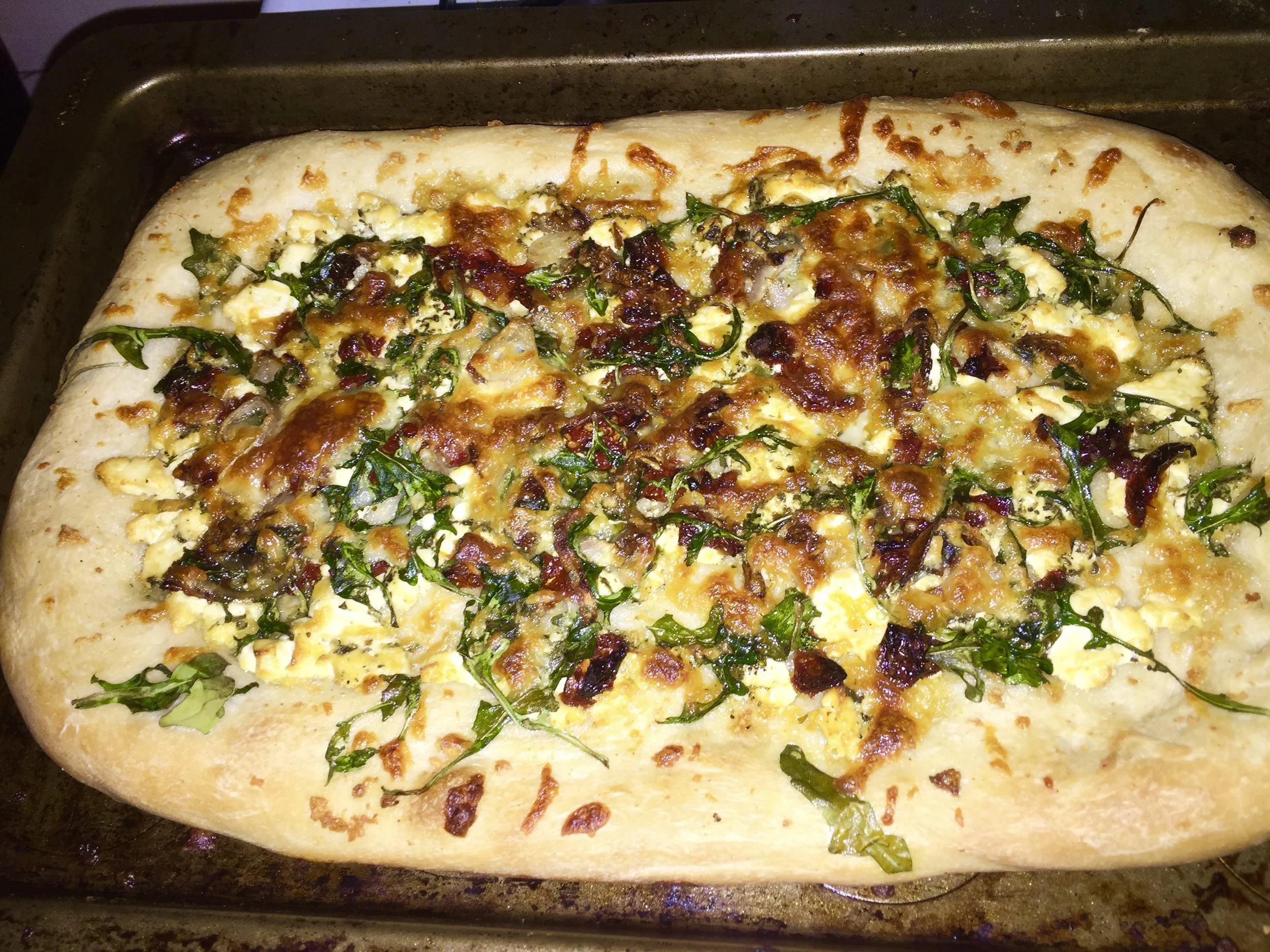 IngredientsPrepackaged Pizza DoughShallot (medium)2-3 cups of arugulacup of sun dried tomatoesmedium log of goat cheese (I used herbes de provence- chèvre variety)Fresh mozzarella (to taste)tbs brown sugarolive oil&nbsp;crushed garlic (to taste)&nbs…