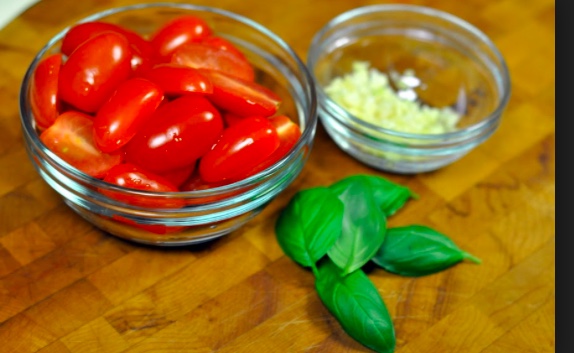  Ingredients 9-13 Roma (Plum) Tomatoes Head of Garlic Big Bunch of Basil Tbls of brown sugar (optional) salt and pepper (To taste) Olive Oil Plan of Attack Core and chop the tomatoes. This sauce is meant to be textural so make sure the tomatoes are not diced but are instead sm, slightly under bite sized. Dice the Garlic (some people add 5-6 cloves, I generally add more than every recipe requires, so make according to your preference). Coat the bottom of your stockpot with olive oil. Turn on stop top and when oil is hot add garlic. Saute garlic until aromatic and keep checking, to confirm it is not burning or sticking to the pot. You may have to add more olive oil. Add tomatoes to pot once garlic is cooked. Using a wood spoon mix garlic, oil and tomatoes. Cook tomatoes until they taste cooked (about 30 minutes). Sauce might have come to a boil. Add basil, ( which has been roughly chopped) and simmer. Add salt, pepper and brown sugar, taste and remove from heat. Serve over pasta while hot! Works well with linguine and tortellini especially! My comments: Kay Cessaro is my sauce hero! Simple recipes, super healthy and honestly, a revelation when it comes to what to do with your garden's abundance of tomatoes! Recipe freezes surprisingly well and I was eating sauce from last summer's garden up through December of this year! 