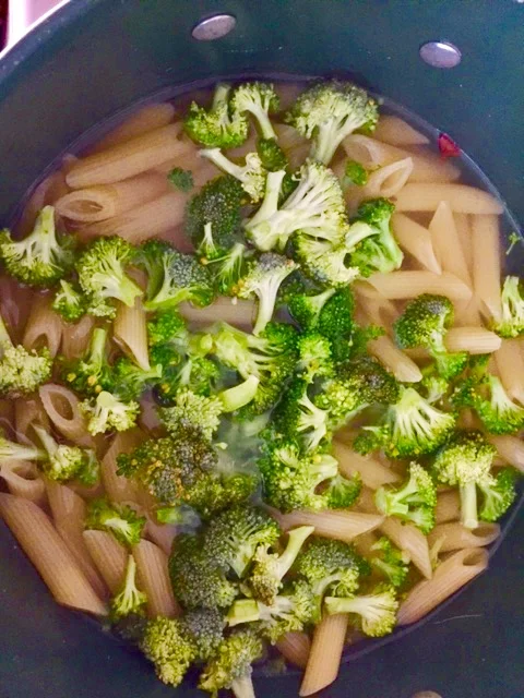 While cutting chicken, boil a pot of salt water. When it is a rolling boil, add the pasta. At minute nine, add the chopped broccoli. When broccoli is cooked and pasta is al dente, drain the broccoli/pasta mixture.Add the remaining tbs of butter to t…