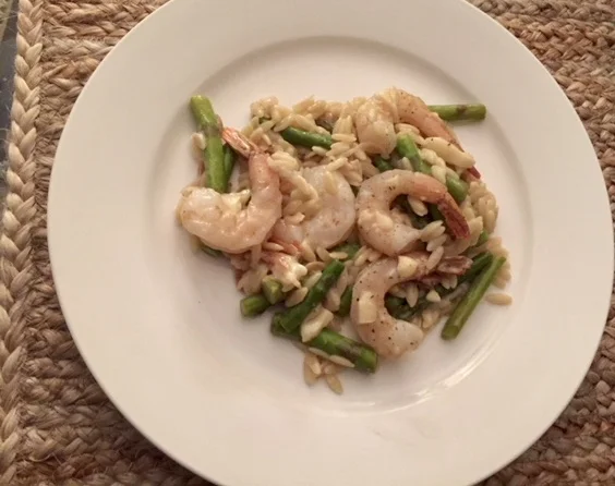 Ingredients Shrimp 9 - 13 deveined and peeled raw 2-3 medium cloves of garlic Shallot Lb of Fresh Asparagus cup of orzo tbs (or so) of olive oil salt and pepper lemon chicken stock (2 cups) 0.5 cup of grated parmesean Plan of attack Preheat the oven to 350 Add olive oil, diced garlic and shallots to a medium deep skillet. Cook over medium heat until onions are clear.