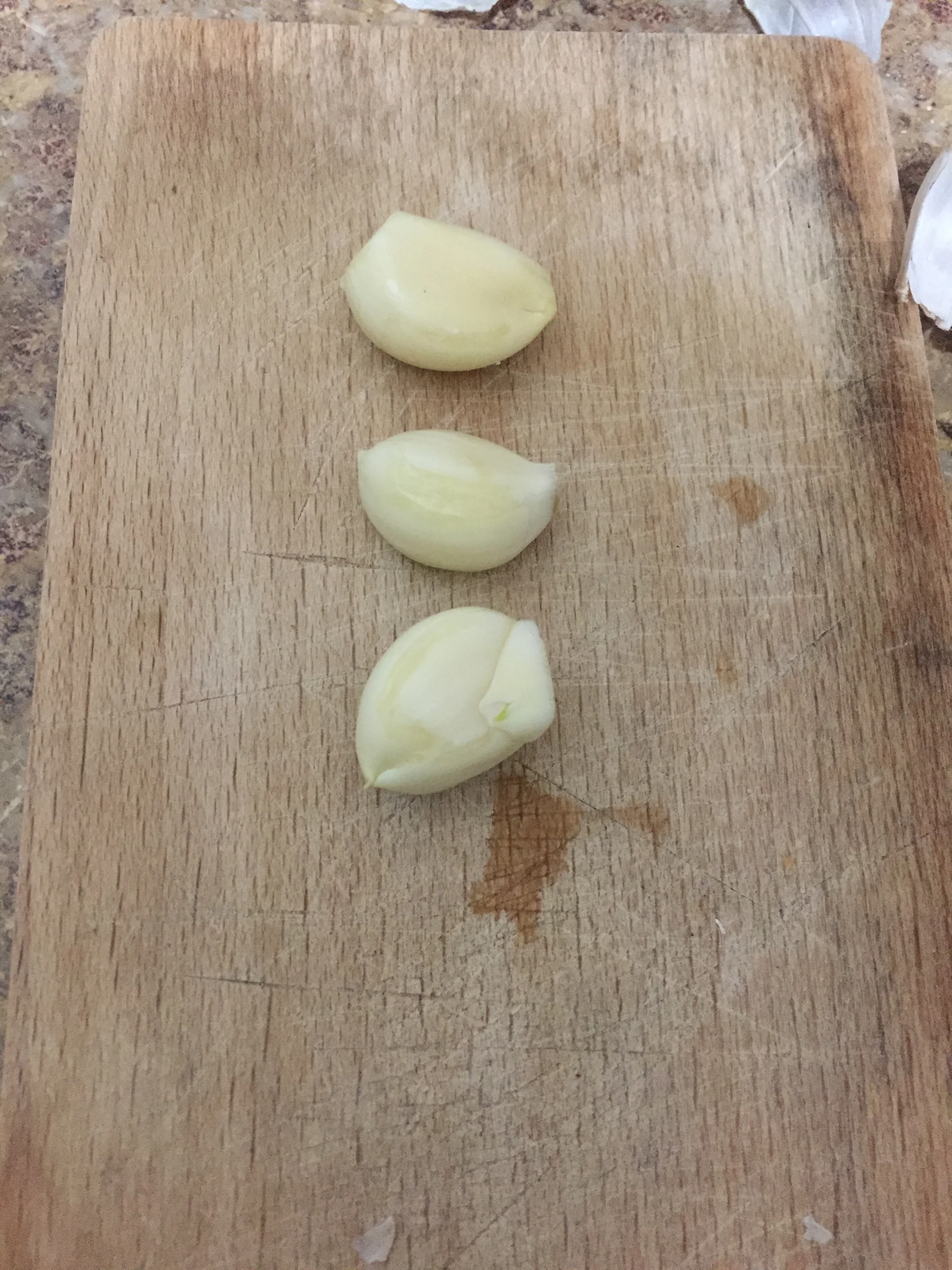 Dice the garlic cloves and add to a skillet coated in olive oil on medium heat, being careful not to overcook or burn.