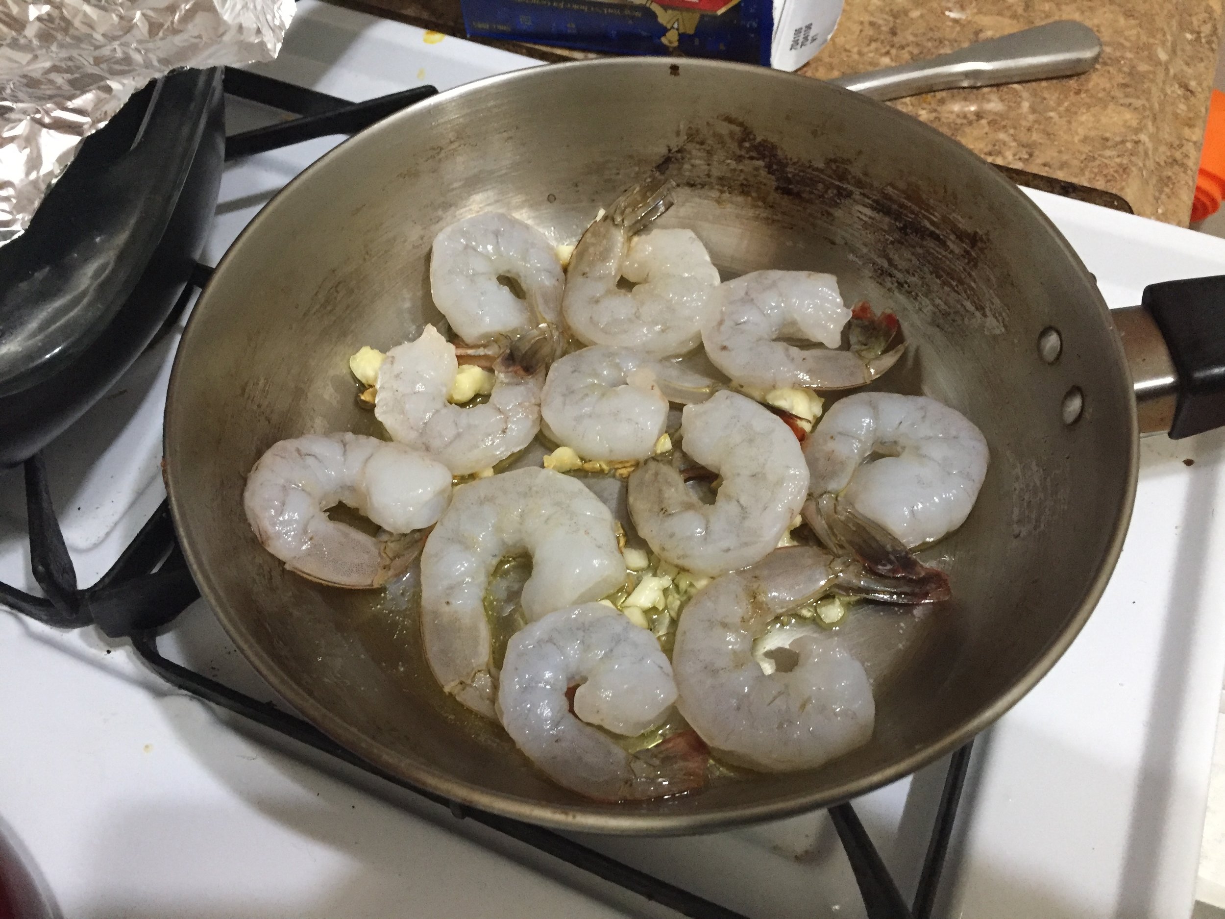 Add the shrimp to the skillet with the garlic and olive oil. Cook throughly on medium heat, turning to cook both sides.