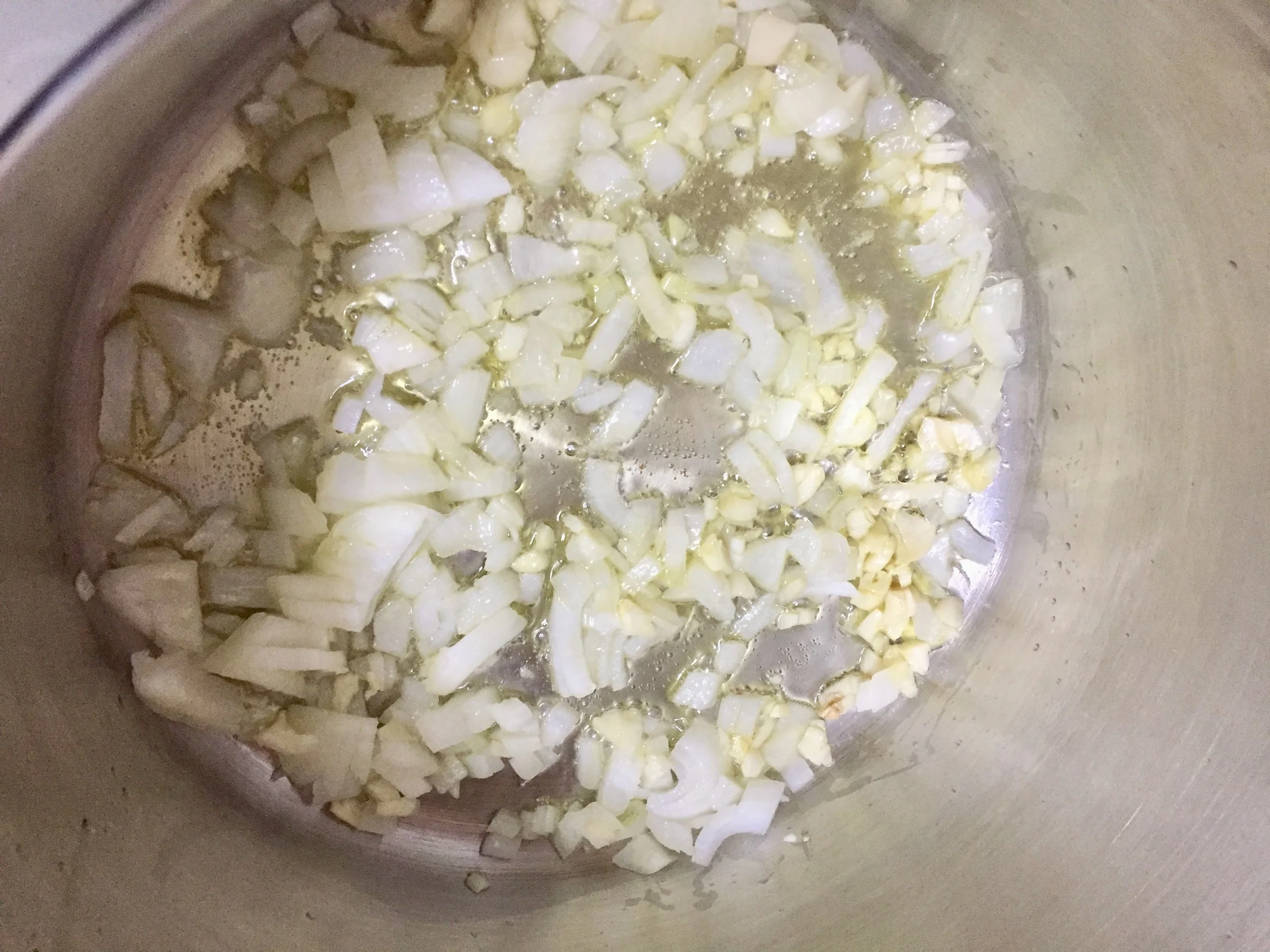 Coat the bottom of your stockpot with olive oil and turn on medium heat. Add the onions and garlic and cook until the onions are clear.