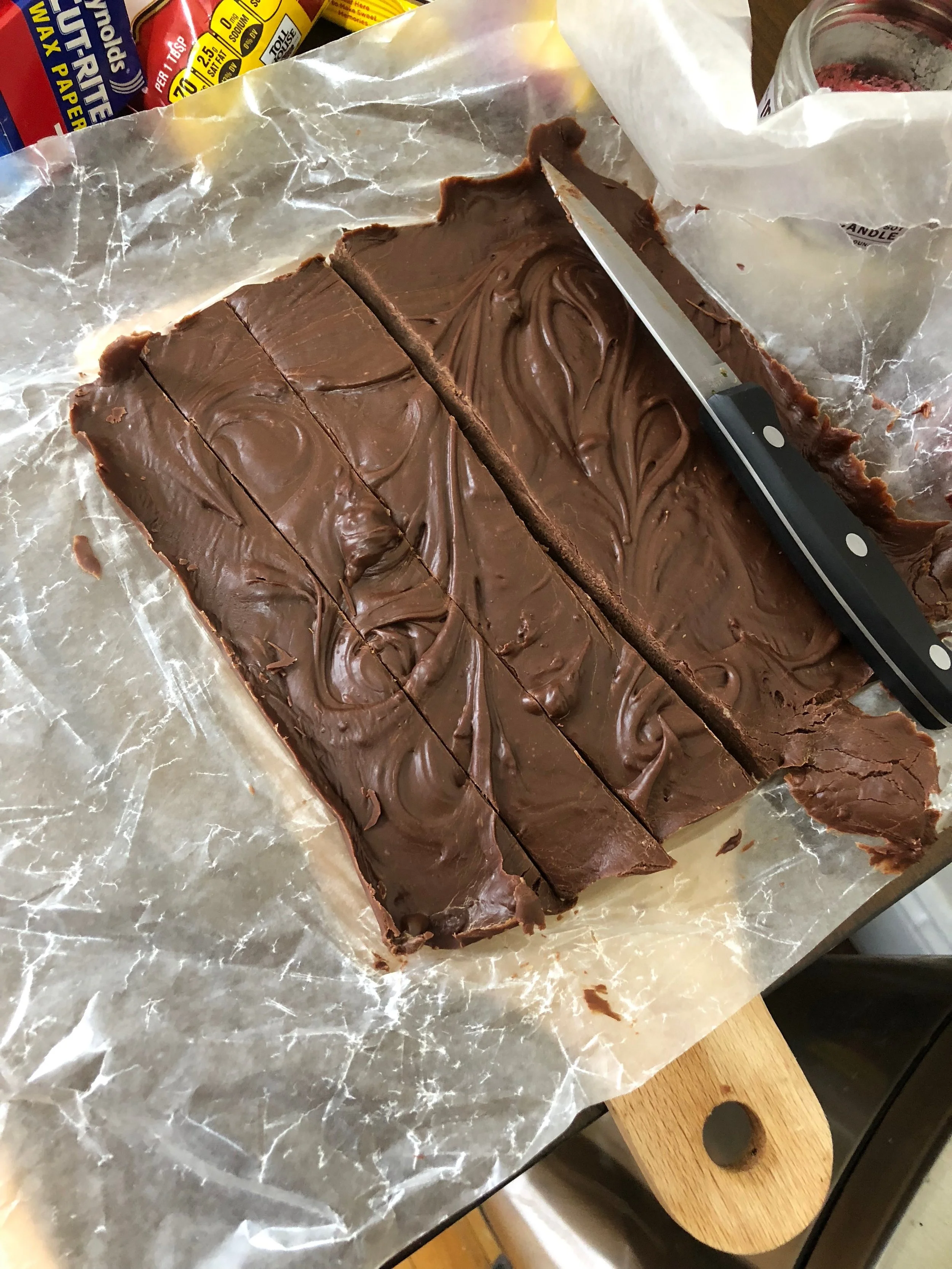 Remove the wax paper from the fridge and place on a cutting board. Slice into rows. You'll know the fudge has set if it slices easily.