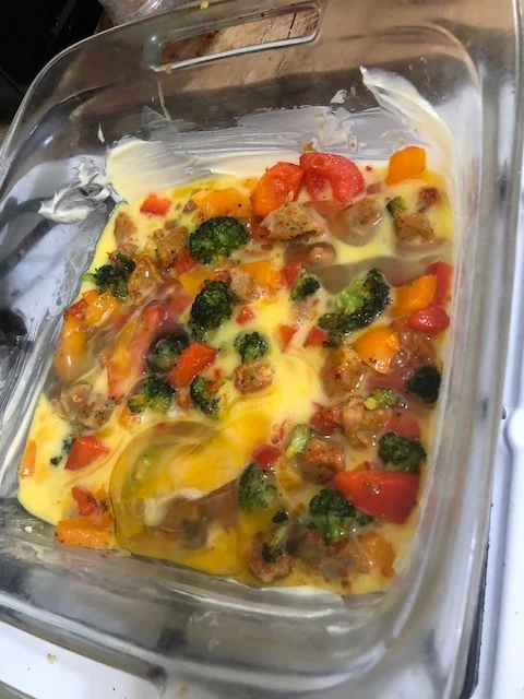 Pour some of the egg mixture on top of the vegetables and sausage.