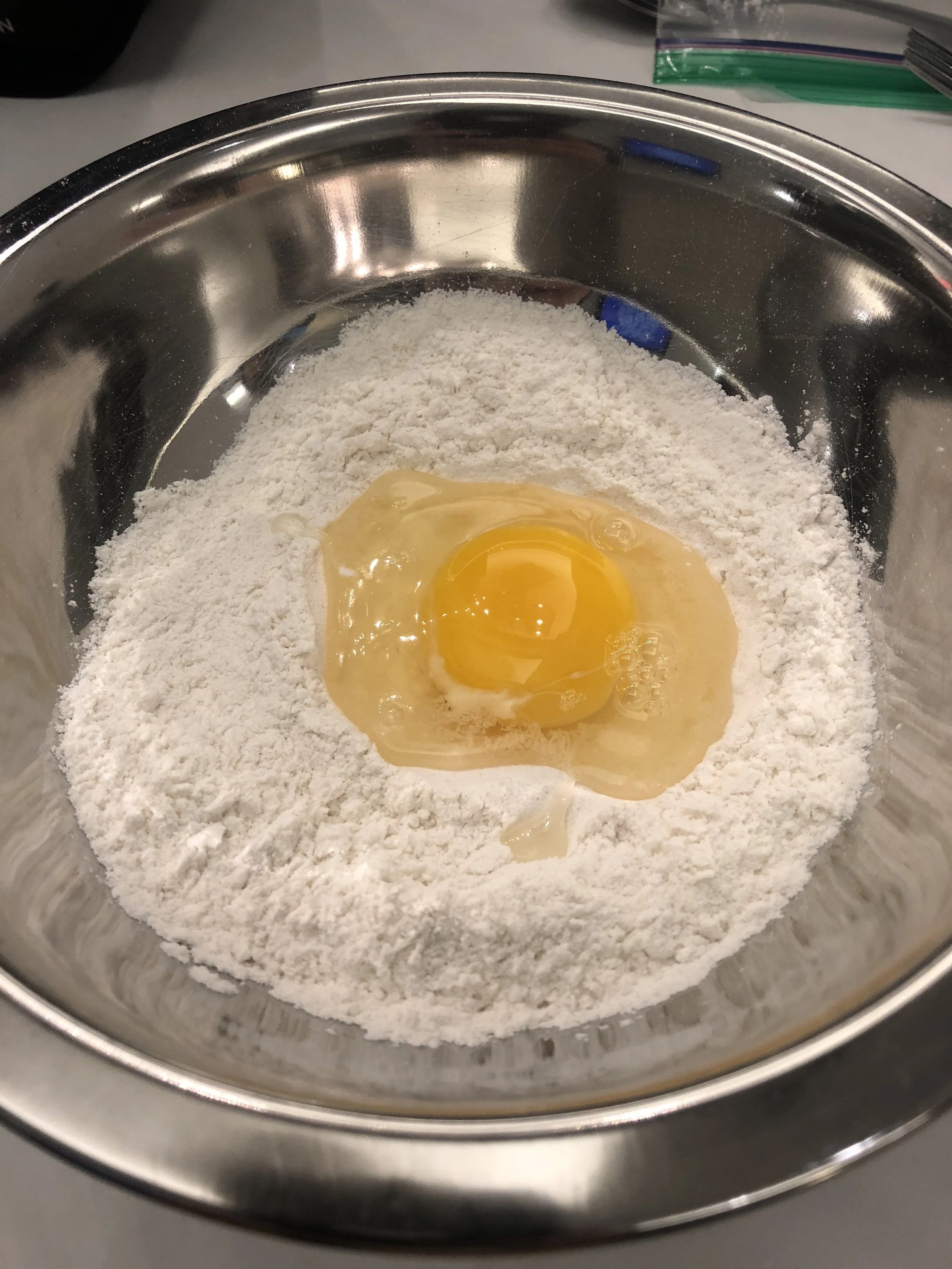 Add your egg(s). Mix with your son and then your hands. Mold into dough and let rest for 30 minutes.