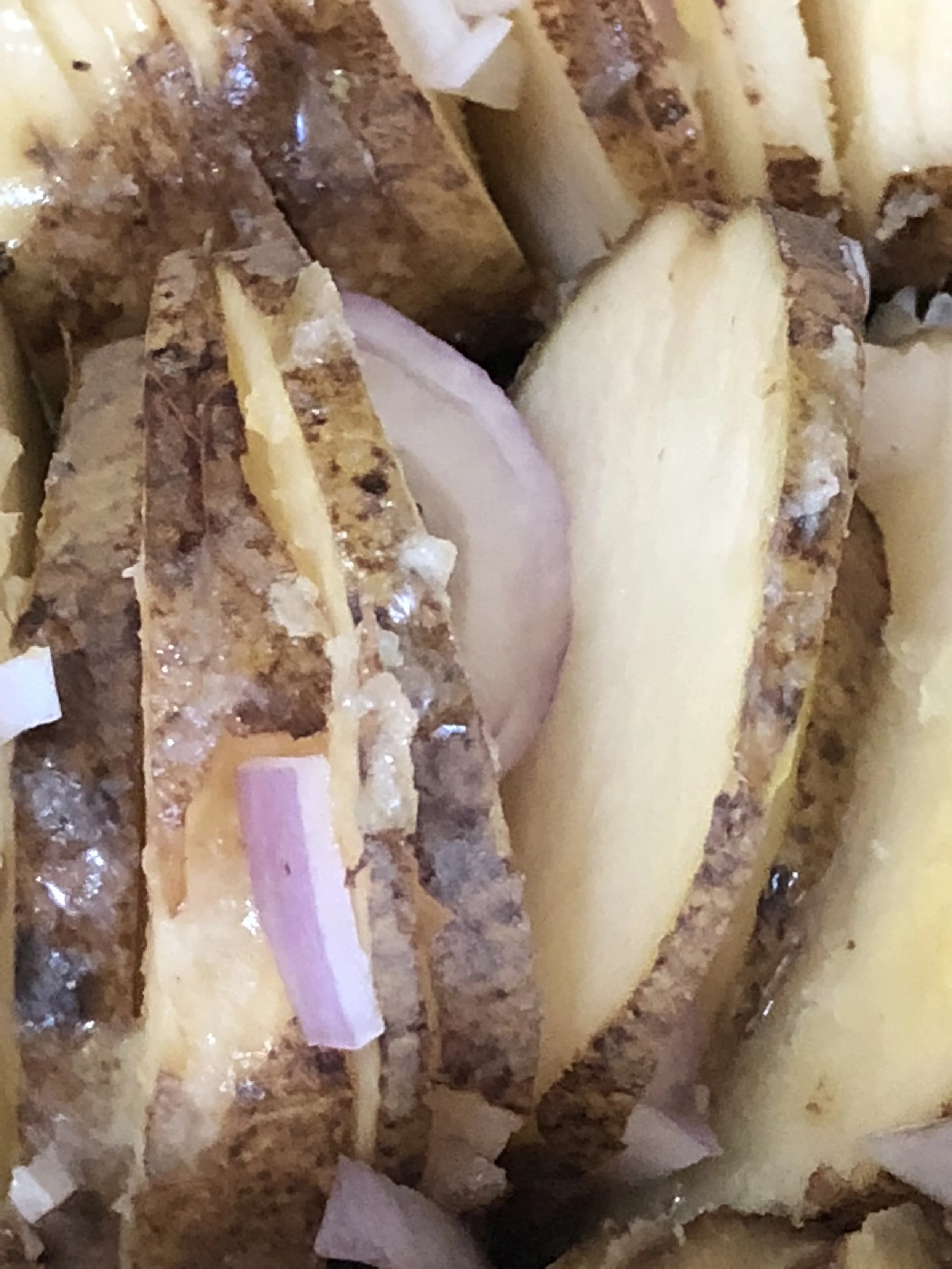 Dice the shallots and individually place in between the slices of potato.&nbsp;