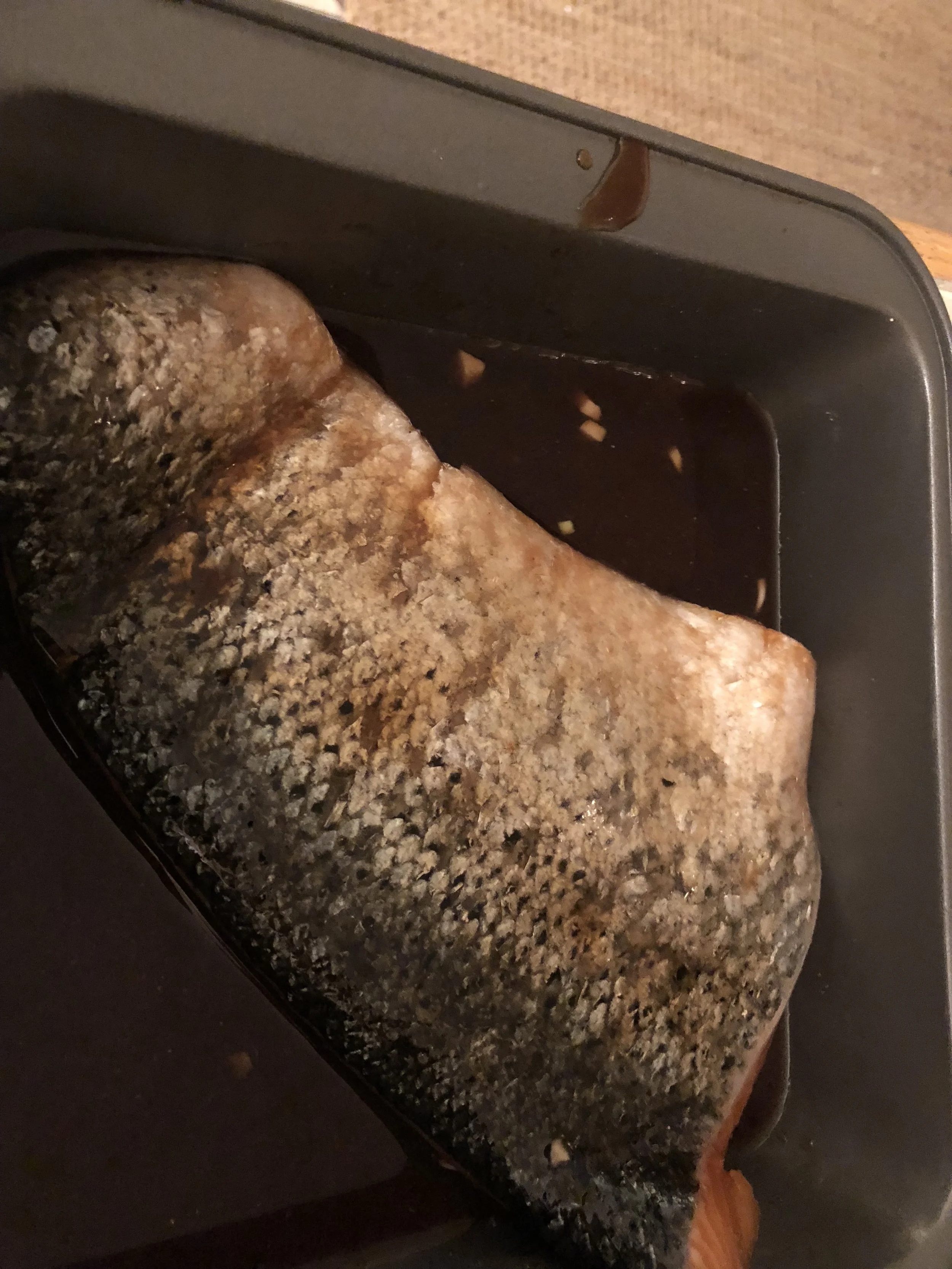 Flip the salmon over so the skin side is up while marinading. After evenly coated, place the pan (with Salmon again skin side down) in the preheated oven. *Original recipe called for this salmon to be cooked in a grill basket over a grill, but I ada…