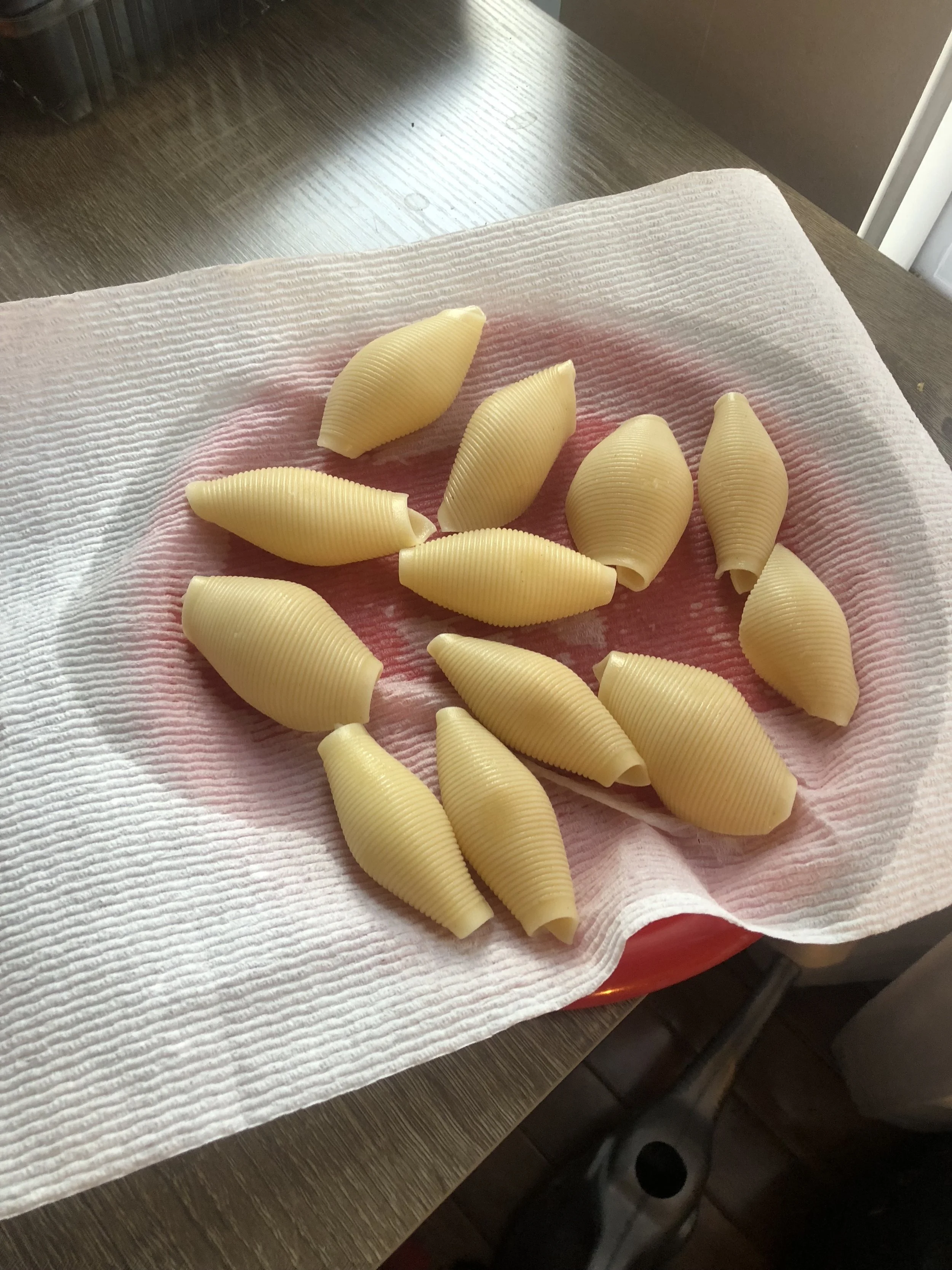 Drain the pasta and rinse in cold water. Place cooked al dente shells onto a paper towel on a plate, with the opening down.&nbsp;