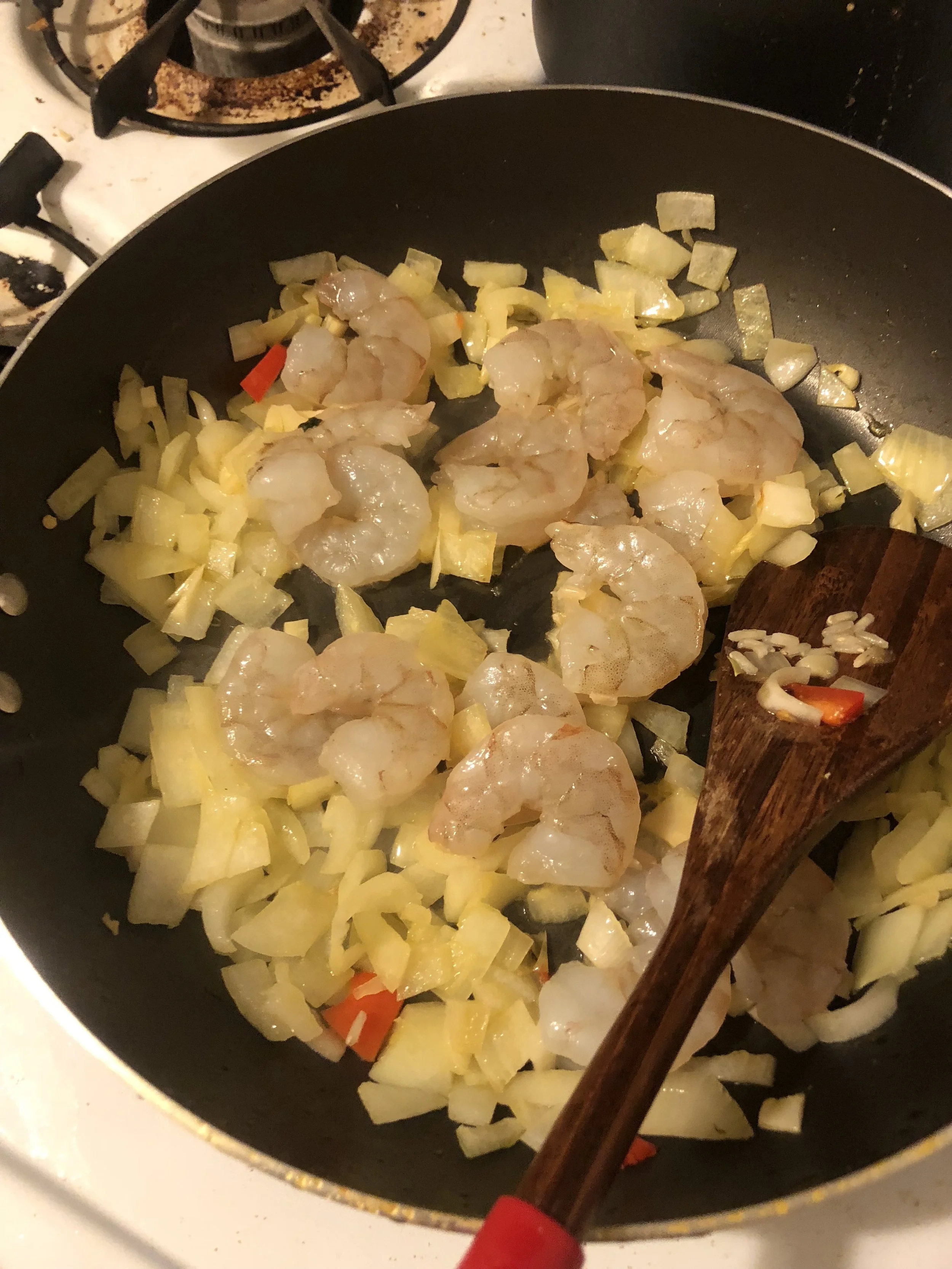 Add the cleaned, rinsed and deveined shrimp to the pan, when the onions and garlic are cooked through and onions are clear. Cook the shrimp until visibly cooked.