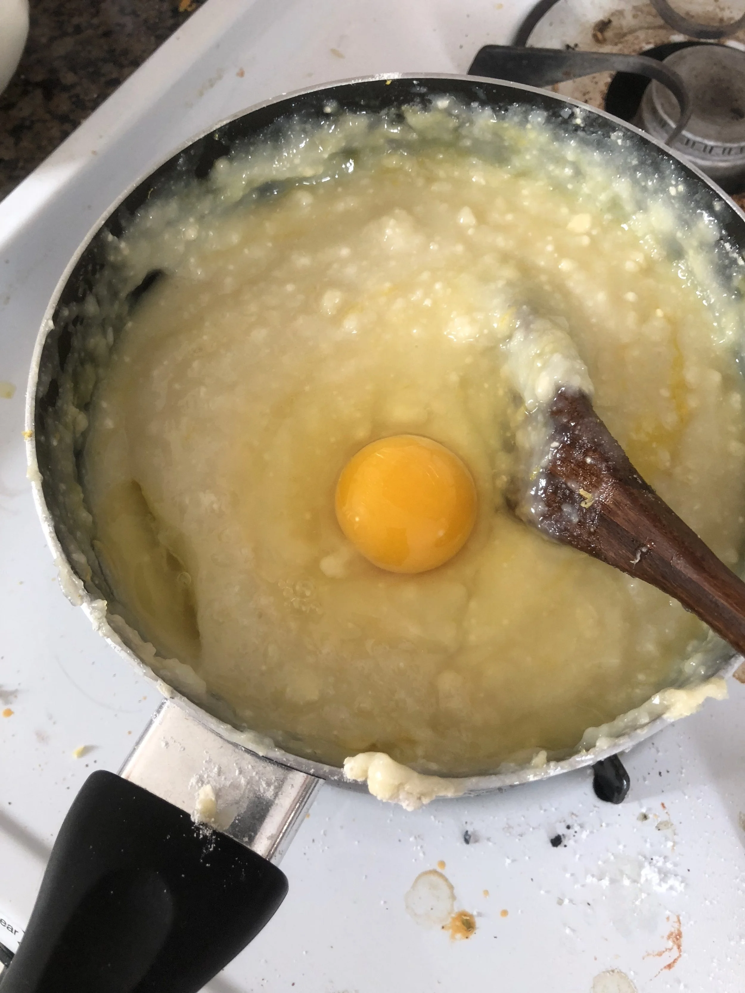 Put the the batter to a bowl to cool it down to warm, stirring frequently to prevent a skin from forming. Add eggs when the mixture cools (if you add the eggs earlier they'll cook in the hot bath of the mixture...