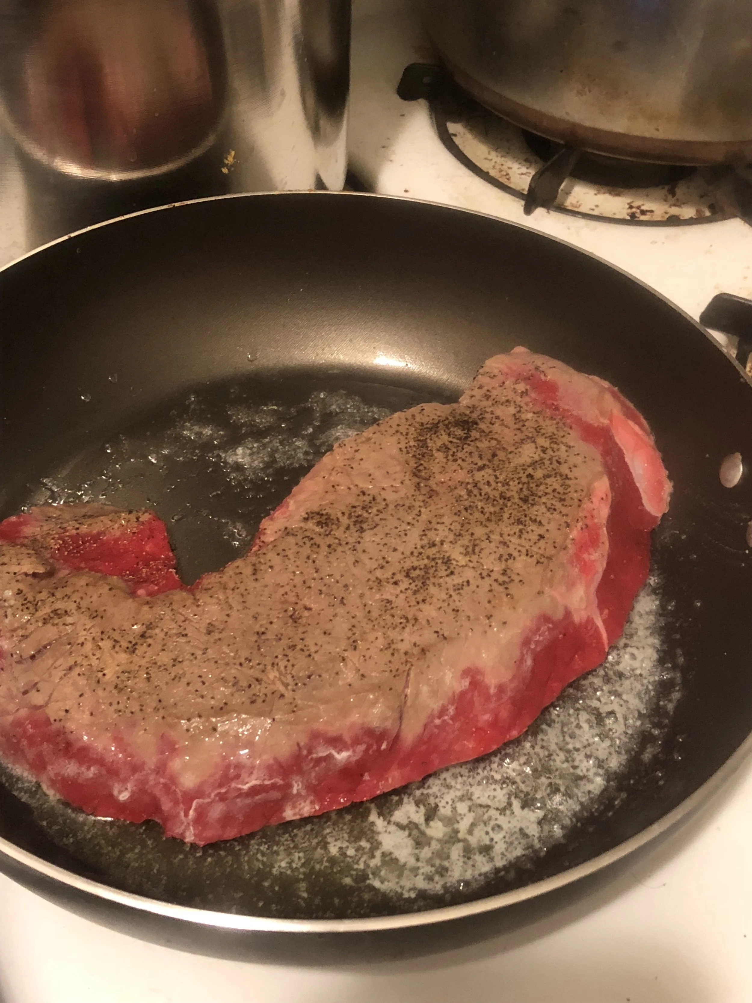 place butter in the bottom of your medium skillet and turn on medium heat. Put the steak in the skillet, turning frequently to cook evenly on both sides. When it is medium well, put it to the side.