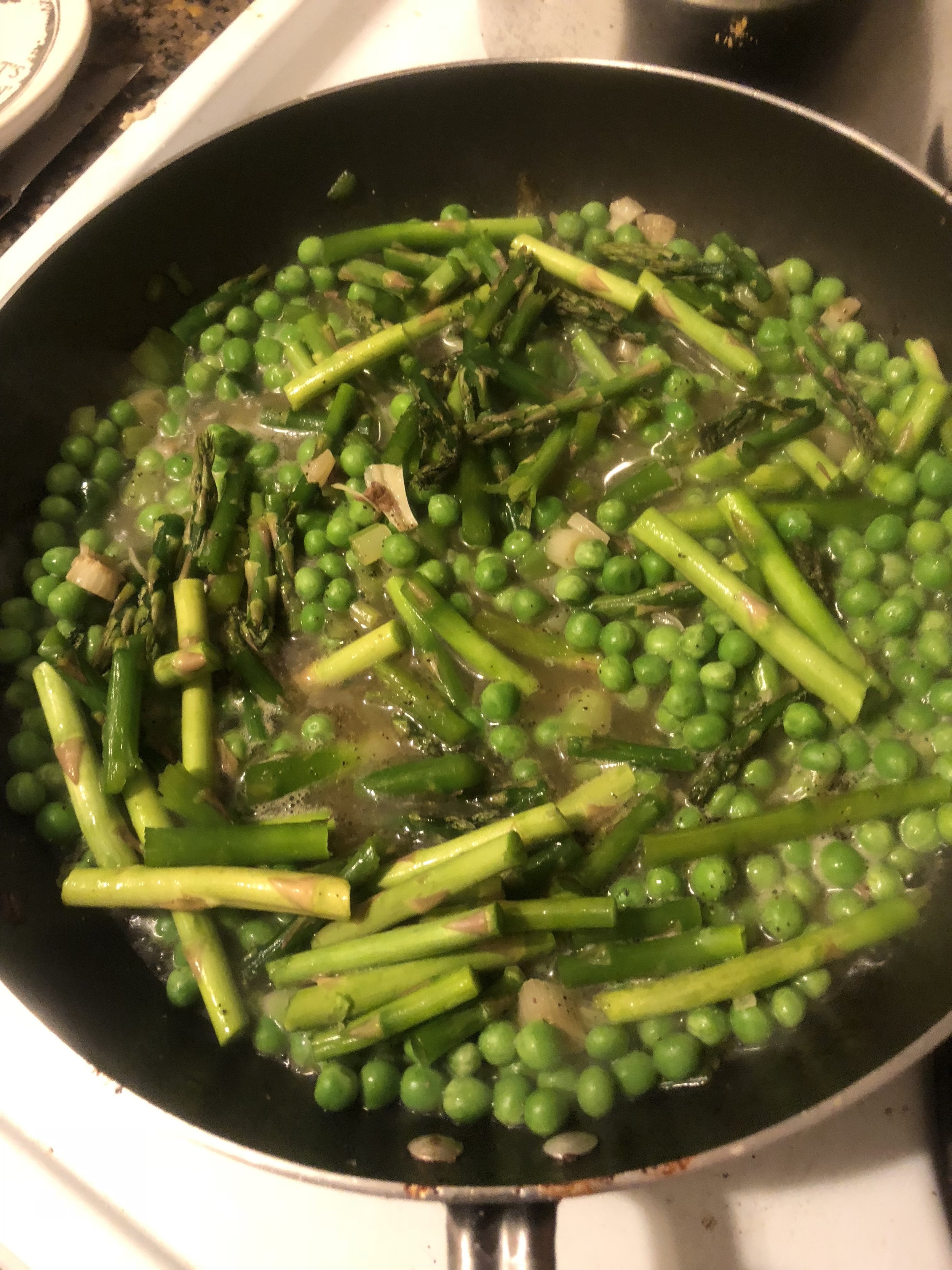 Add peas and asparagus to the pan and cook. While vegetables are cooking, make the sauce.