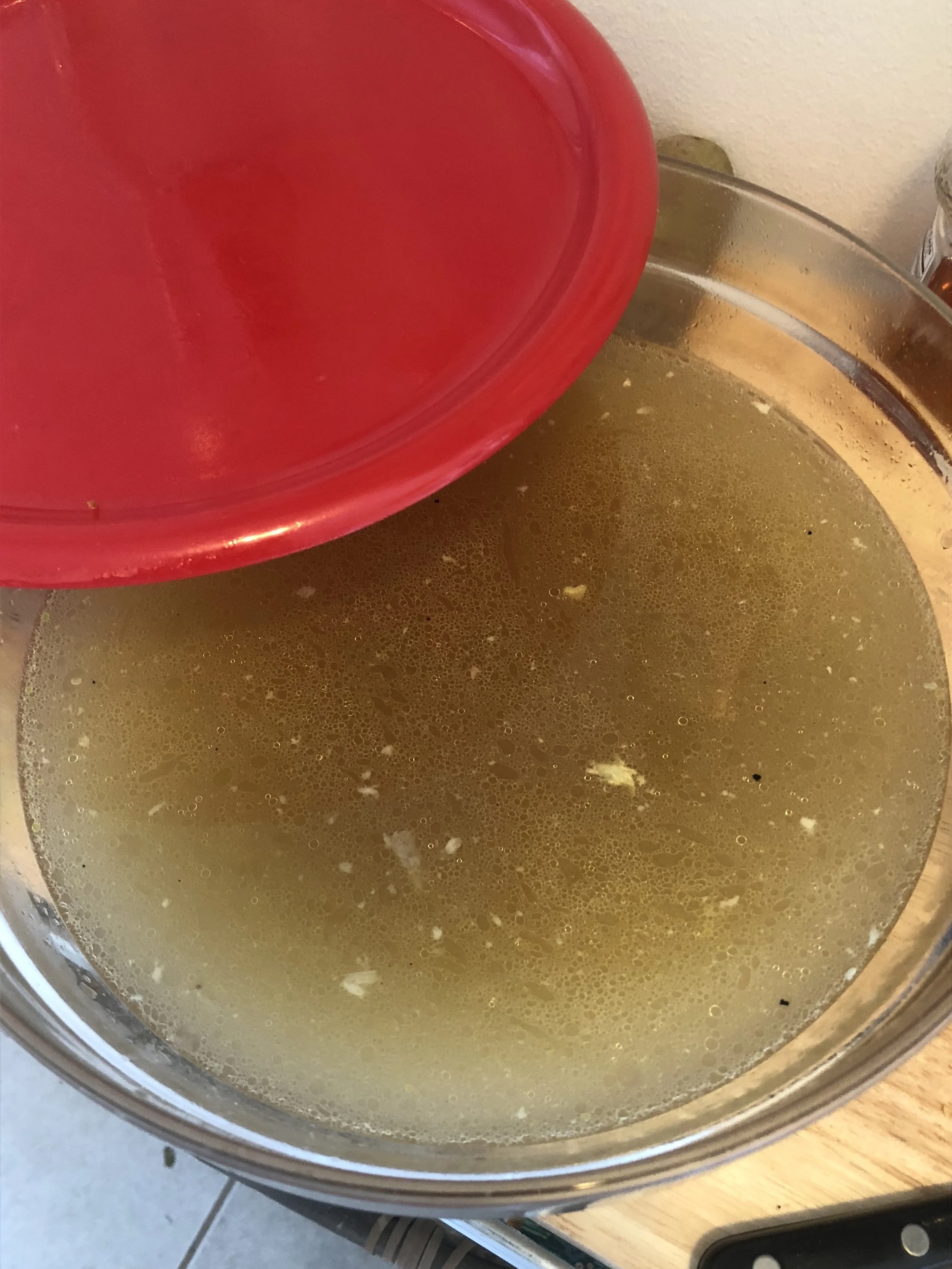 Strain the liquid from the stockpot (your broth). Discard the bones and skin, and season with pepper, garlic and Goya chicken bouillon.