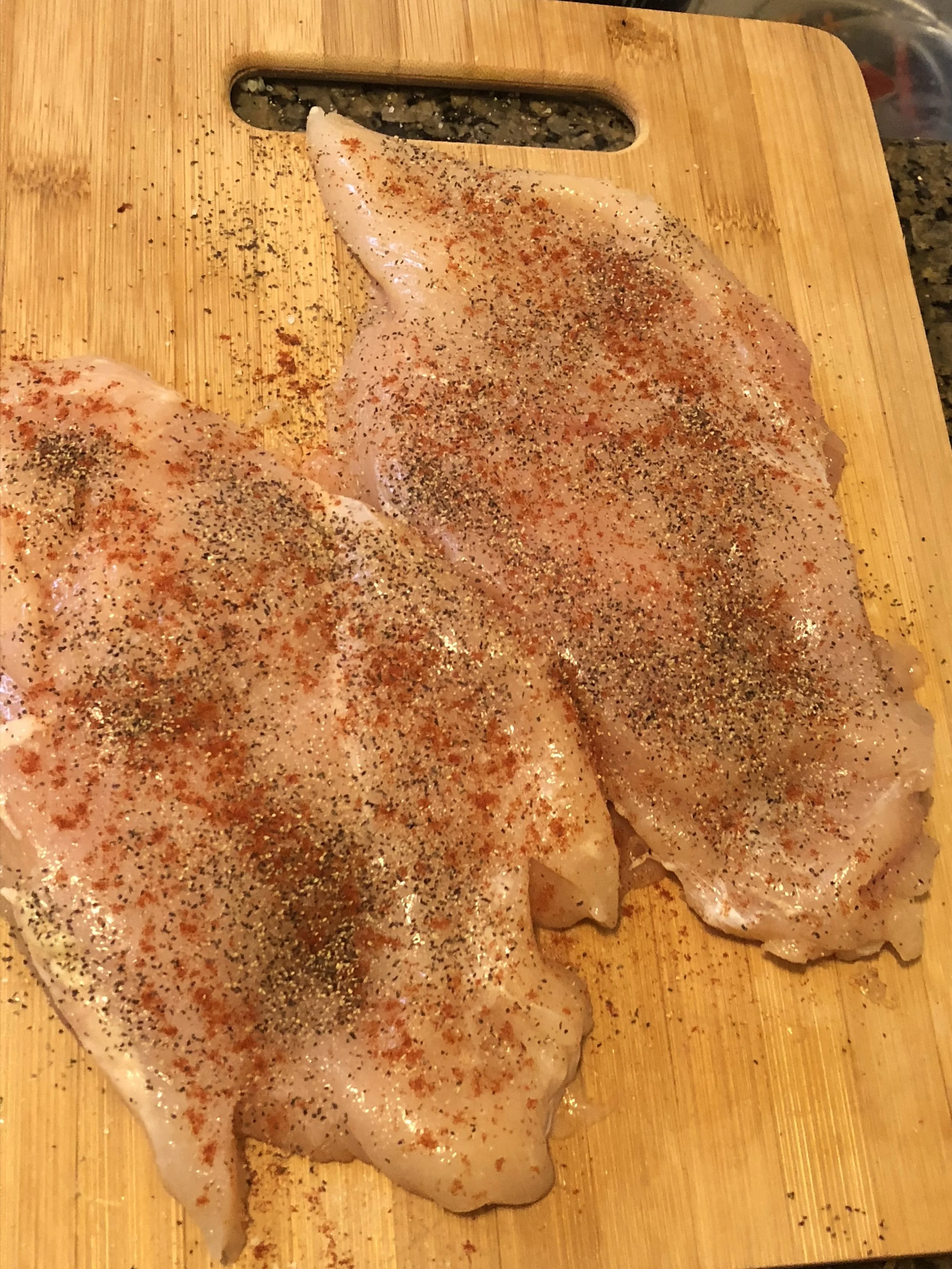 Season the chicken breasts generously with salt, pepper, powdered garlic and paprika. Place the breasts in the bowl you intend on marinating them in, drizzle with love oil, and grate the lemon and garlic cloves over it.