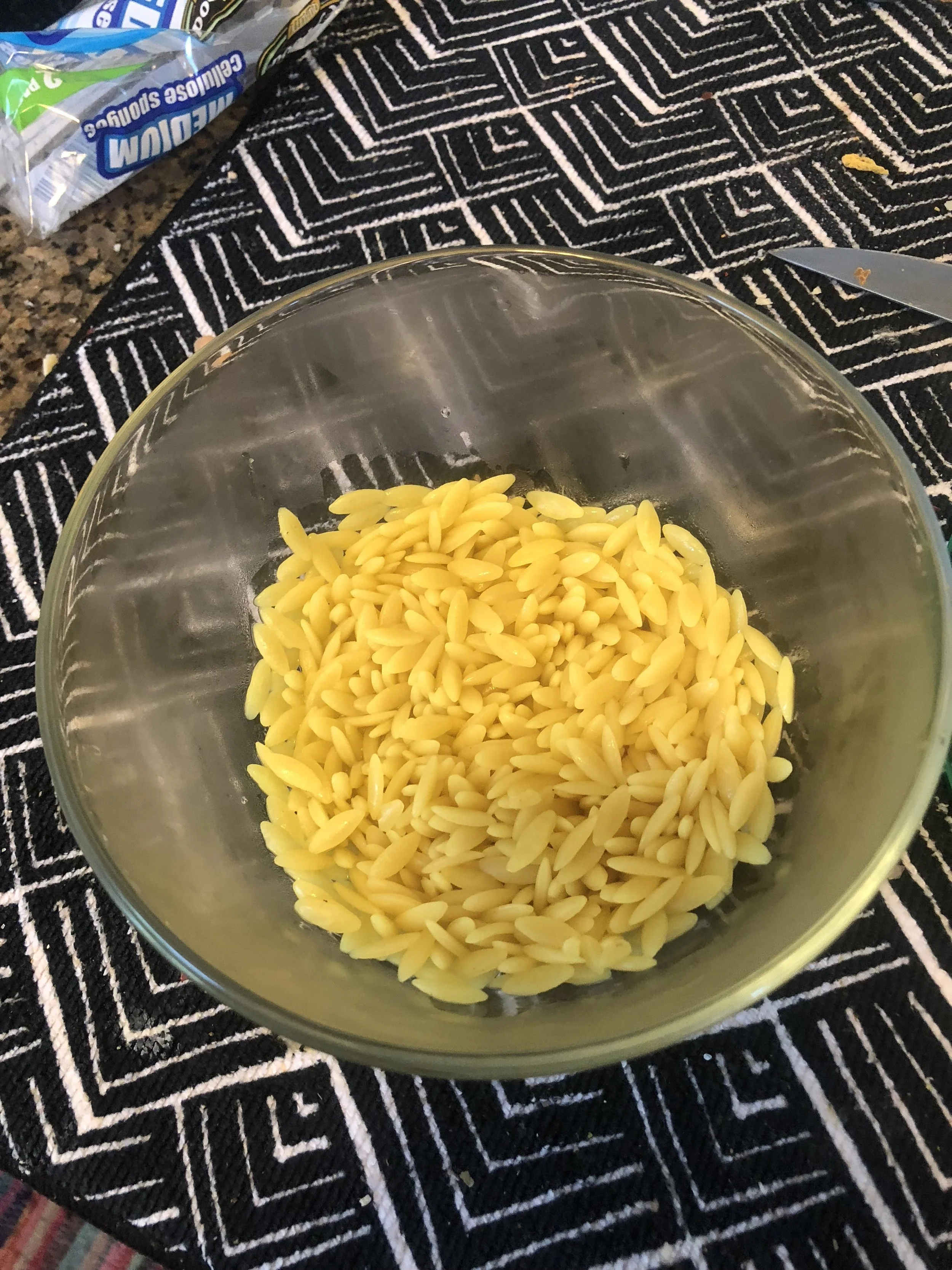 Measure a cup of Orzo and put a medium saucepan with 2-3 cups of water on to boil. Add seasoning to the water and when it boils, add the orzo. Cover and cook for 9-13 minutes.