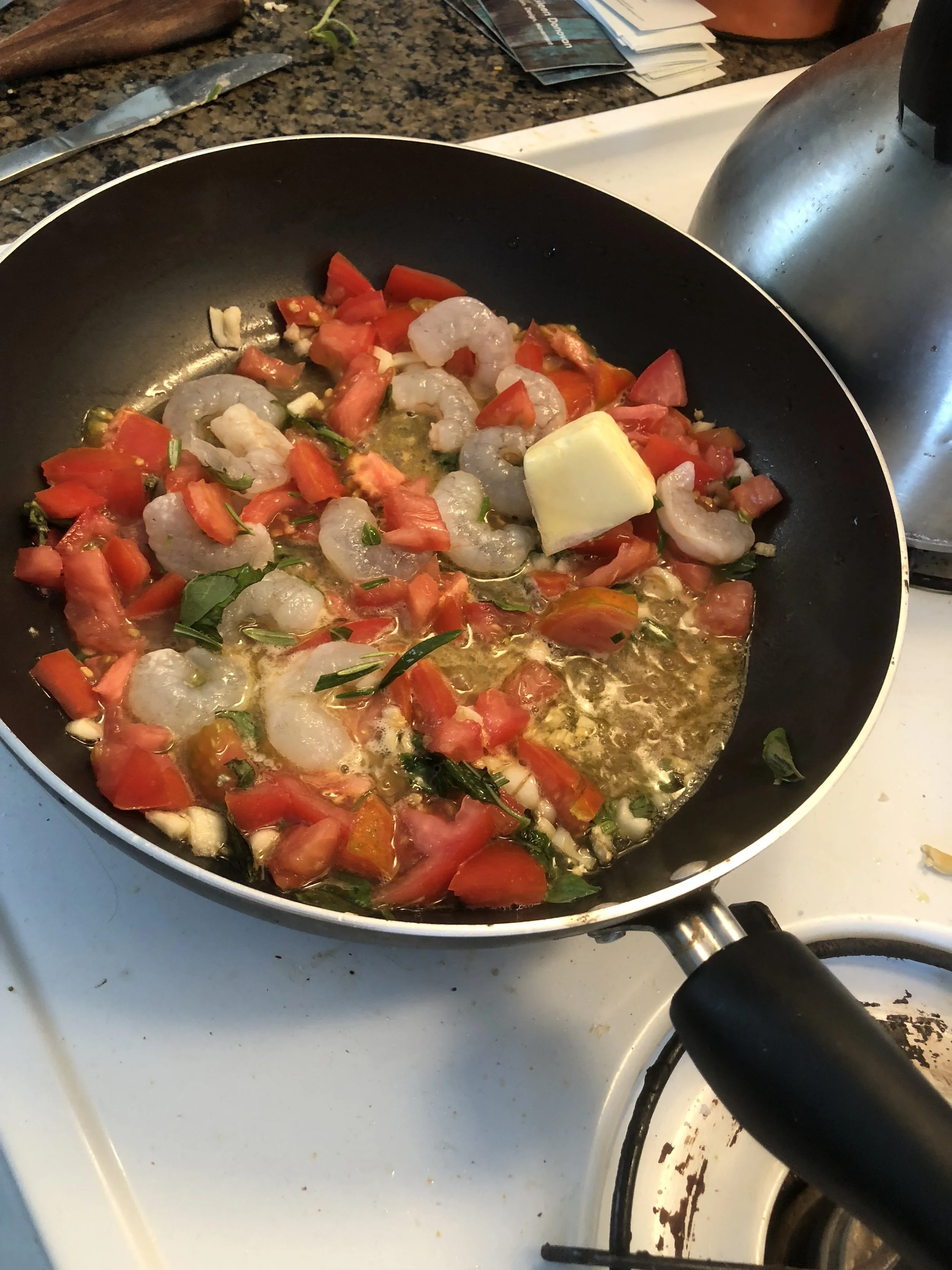 Add the butter, diced tomatoes, basil and rosemary to the medium frying pan. Cook until the the shrimp are cooked through and the ingredients have integrated into their own sauce. While the sauce is cooking, bring water in your stockpot to healthy boil and when it is boiling, add the pasta which has been setting. Cook until the pasta floats to the top.