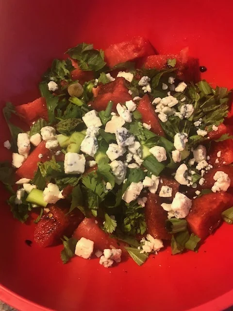 Ingredients 2 cups of watermelon 0.65 cup of balsamic vinegar 2-3 green onions (scallions) sm bunch of cilantro 0.5 cup of gorgonzola cheese Plan of Attack Pour your vinegar in your medium saucepan and turn on medium low for 13-15 minutes, resulting in a very concentrated liquid. Put aside to cool. Add the watermelon, diced scallions, roughly chopped cilantro and gorgonzola into your medium mixing bowl. Pour the cold balsamic reduction (because this what ya just made fancy pants- balsamic reduction!) over the salad. Mix throughly so the salad is covered with the balsamic reduction and the herbs are distributed throughout.