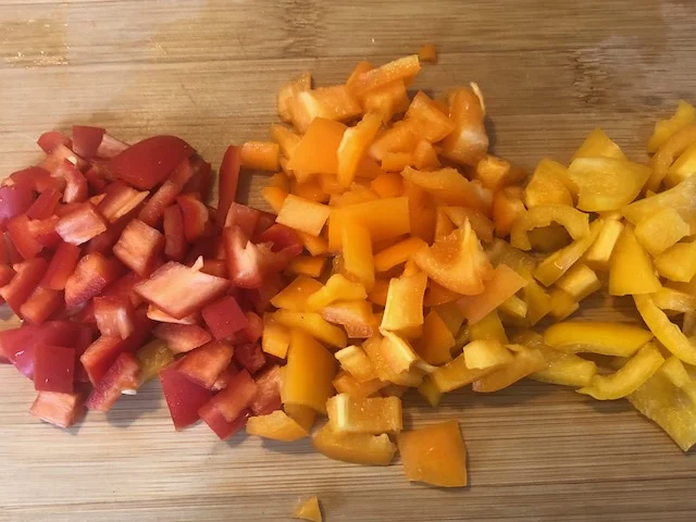 Dice and core your peppers into sm pieces. Clean and skin your onion, and then dice into sm pieces which will cook quickly