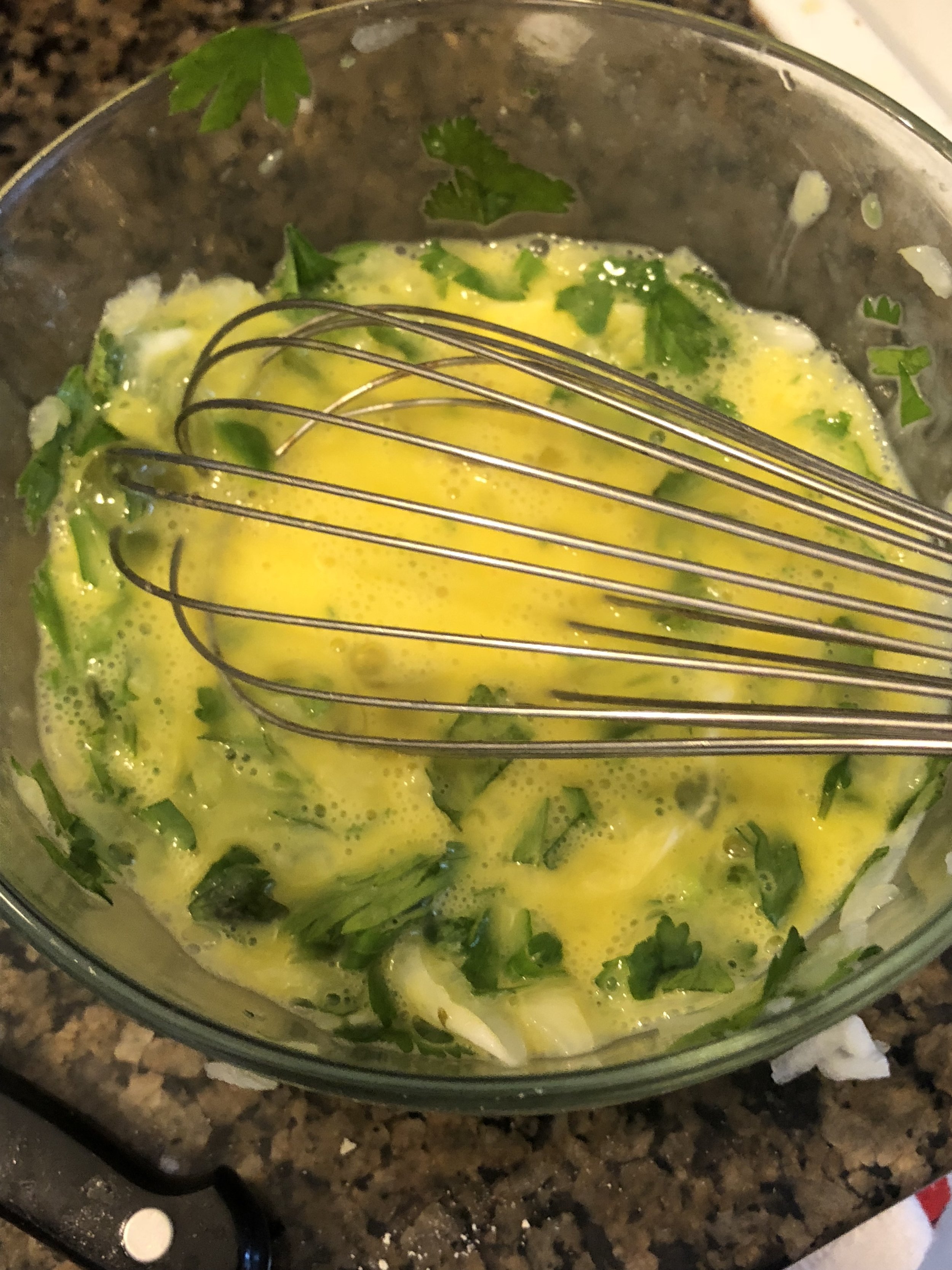 Add 3 eggs and the yolks from two of the eggs into the herb mixture. Add the heated liquid chicken fat to the mixture. Whisk until integrated.