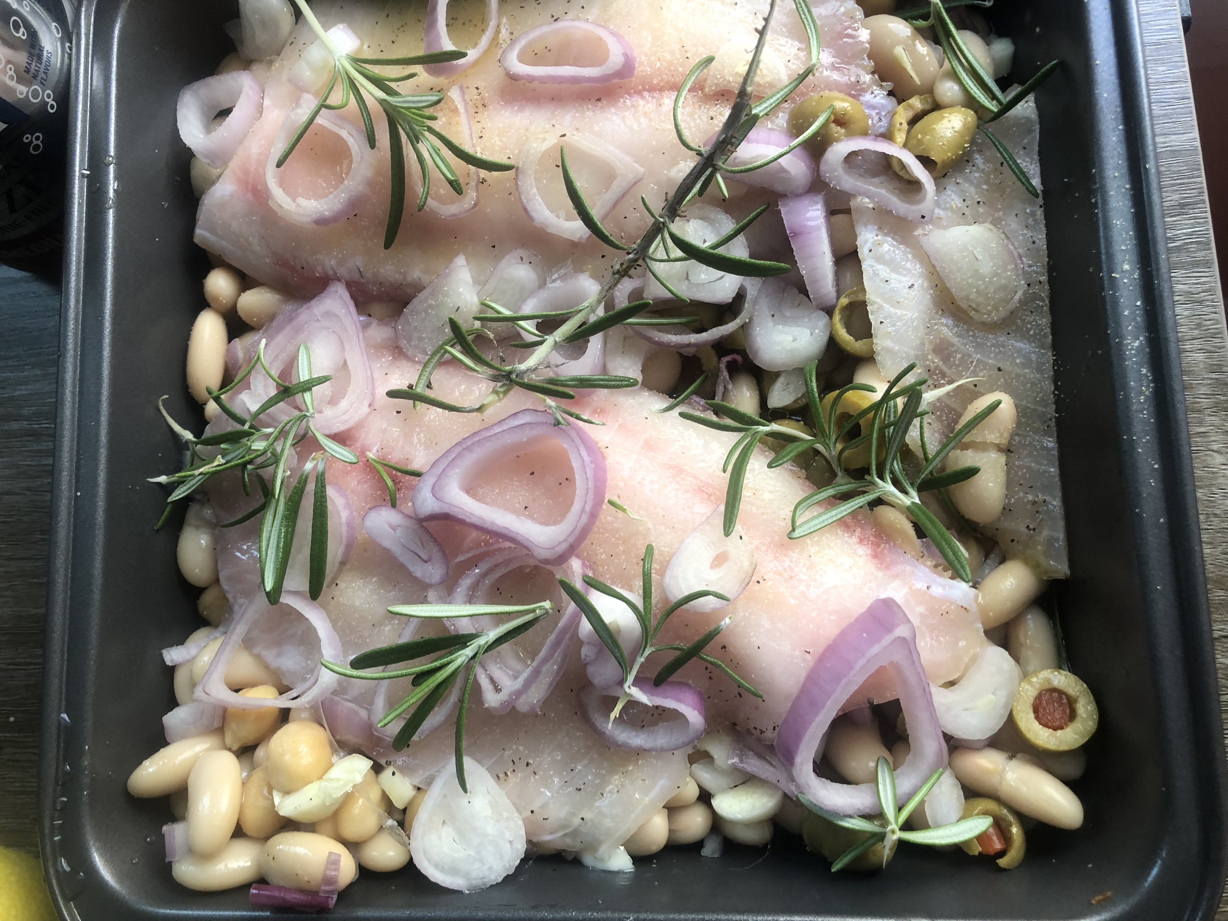 Slt and pepper your fish and cover with rosemary, shallots, and diced garlic. Drizzle with olive oil and cover thinly sliced lemons