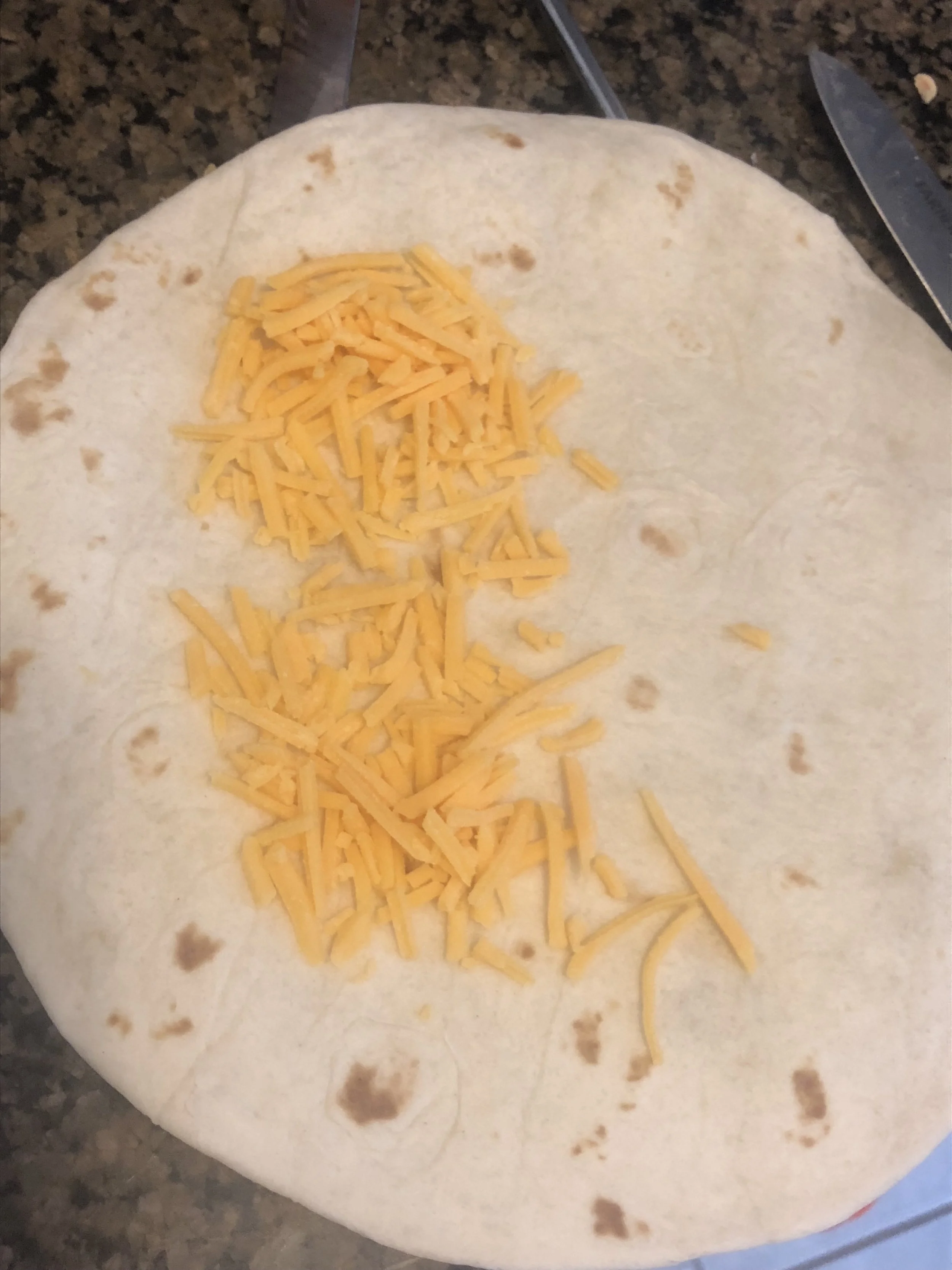 Placed shredded cheese on the left side of the quesadilla