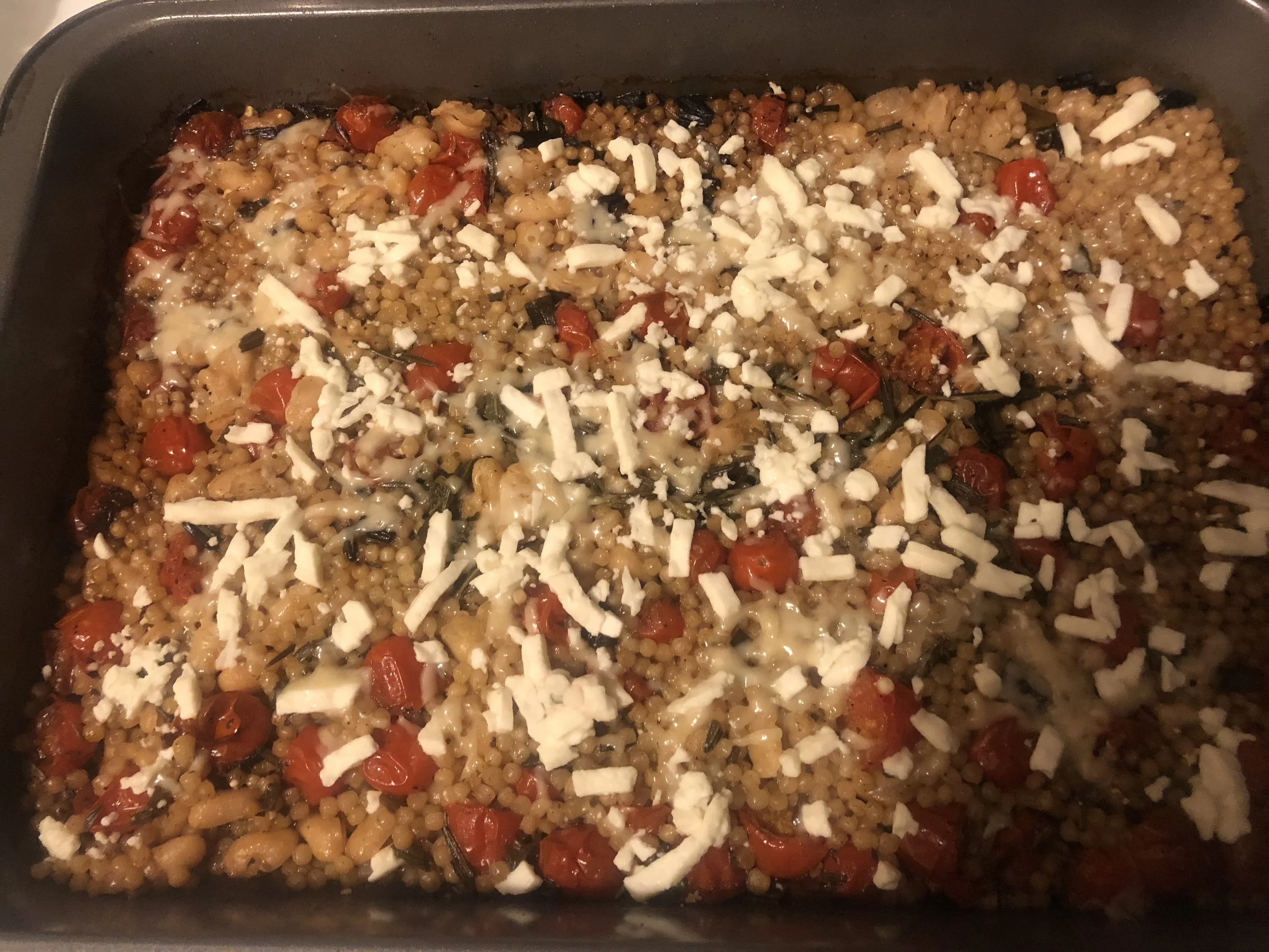 ingredients Pint of grape tomatoes cup of feta 0.5 cup of shredded parmesan 3 sprigs of oregano bunch of scallions 2 tsp of balsamic vinegar 1.5 cup of pearl couscous 2 cups of chicken broth salt and pepper tsp of cumin can of cannelloni beans 2-3 medium/massive cloves of garlic 5-6 tsp of olive oil
