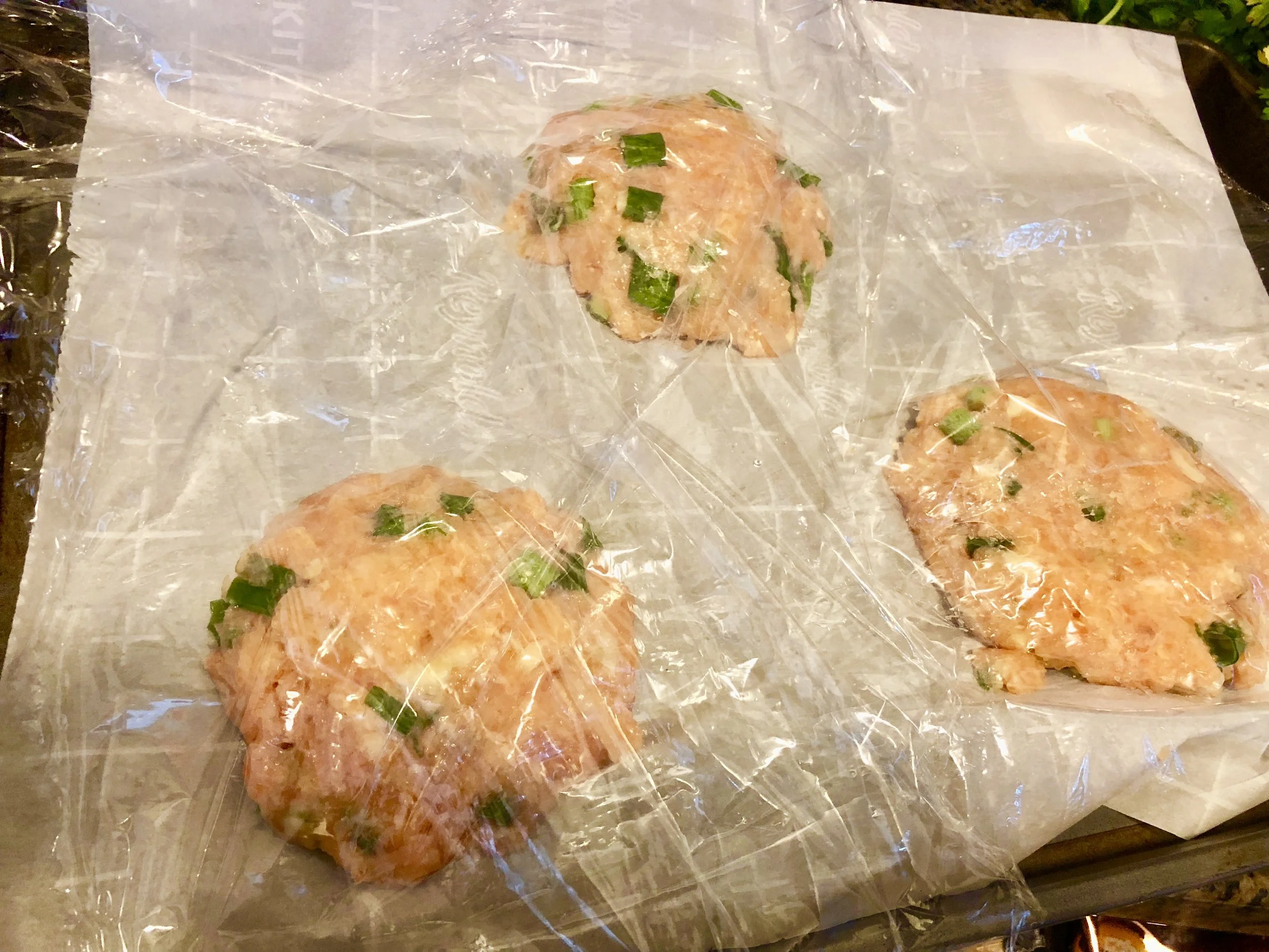 Form the salmon mixture into cakes (they’ll resemble burgers) and place on a parchment lined baking sheet covered in Saran Wrap. Refrigerate the cakes for at least an hour. Slice the cucumber and add the rice wine vinegar and sugar to a bowl. Refrigerate for at least an hour.