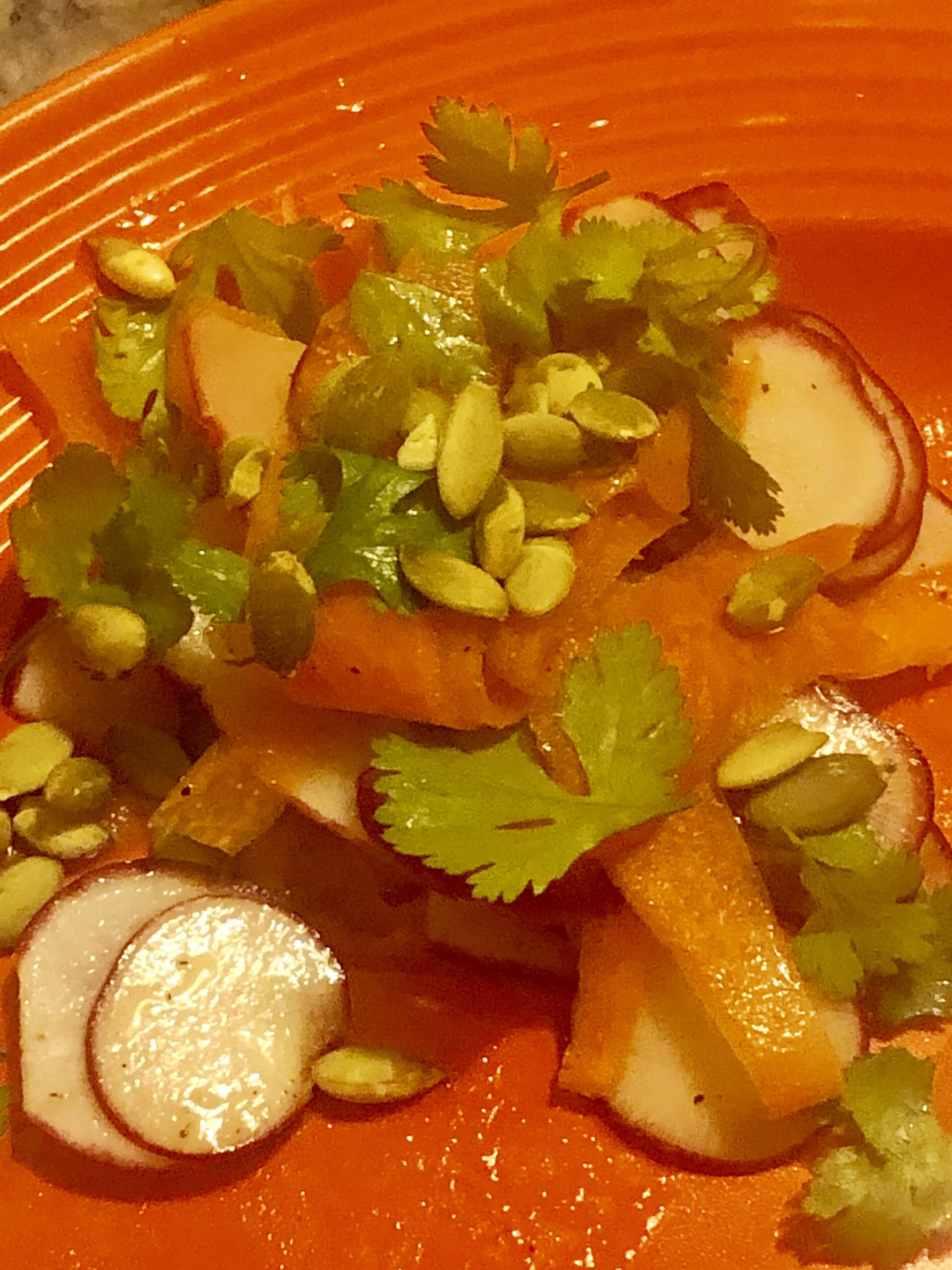INGREDIENTS 1/4 cup olive oil, divided 1 cup raw shelled pumpkin seeds 1/2 teaspoon ground cumin 3/4 teaspoon kosher salt, plus more 3 tablespoons fresh lemon juice 1 teaspoon honey 1/4 teaspoon freshly ground black pepper 2 pounds carrots, peeled, shaved lengthwise into ribbons with a vegetable peeler 1 bunch radishes (approximately 10 radishes), thinly sliced on a mandoline or with a sharp knife 4 cups (packed) mixed torn herbs, such as parsley, cilantro, dill, mint, tarragon, and/or basil